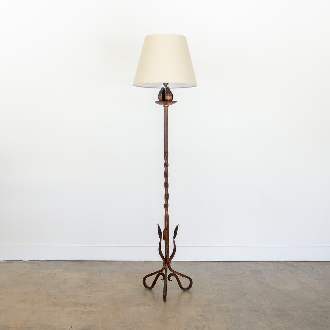 Incredible vintage brutalist wrought iron floor lamp from France, 1940s. Twisted iron stem with leaf detail on three curved etched iron legs. Beautiful leaf detailing. Iron finish has some hints of gold and red tones.  New linen tapered shade and