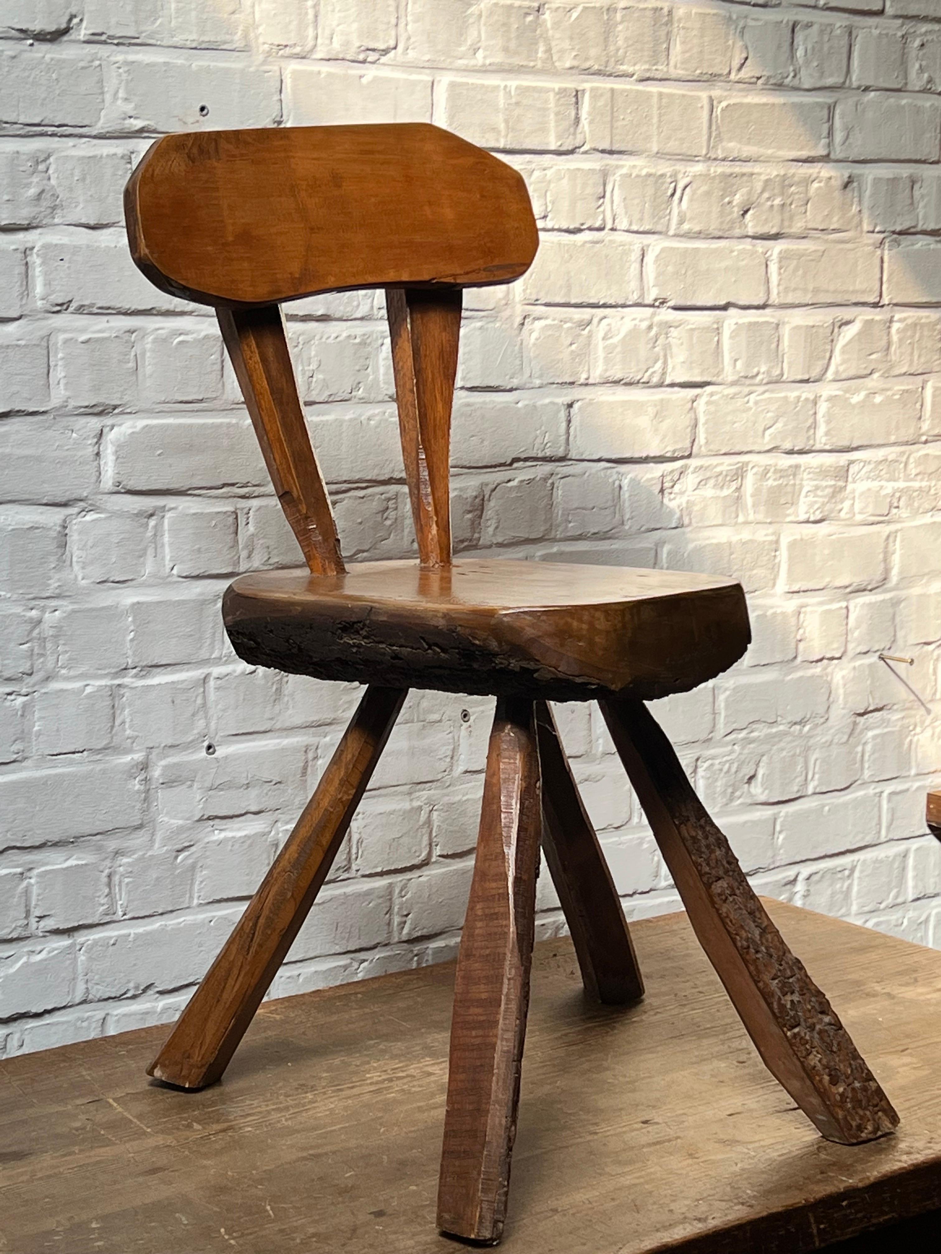 Very unique handmade with massive pine. Unusual chair. The overall is patinated and shows various shades of brown/brownish colors. Elegant and brutalist describe that chair properly. Very strong eye catcher chair.