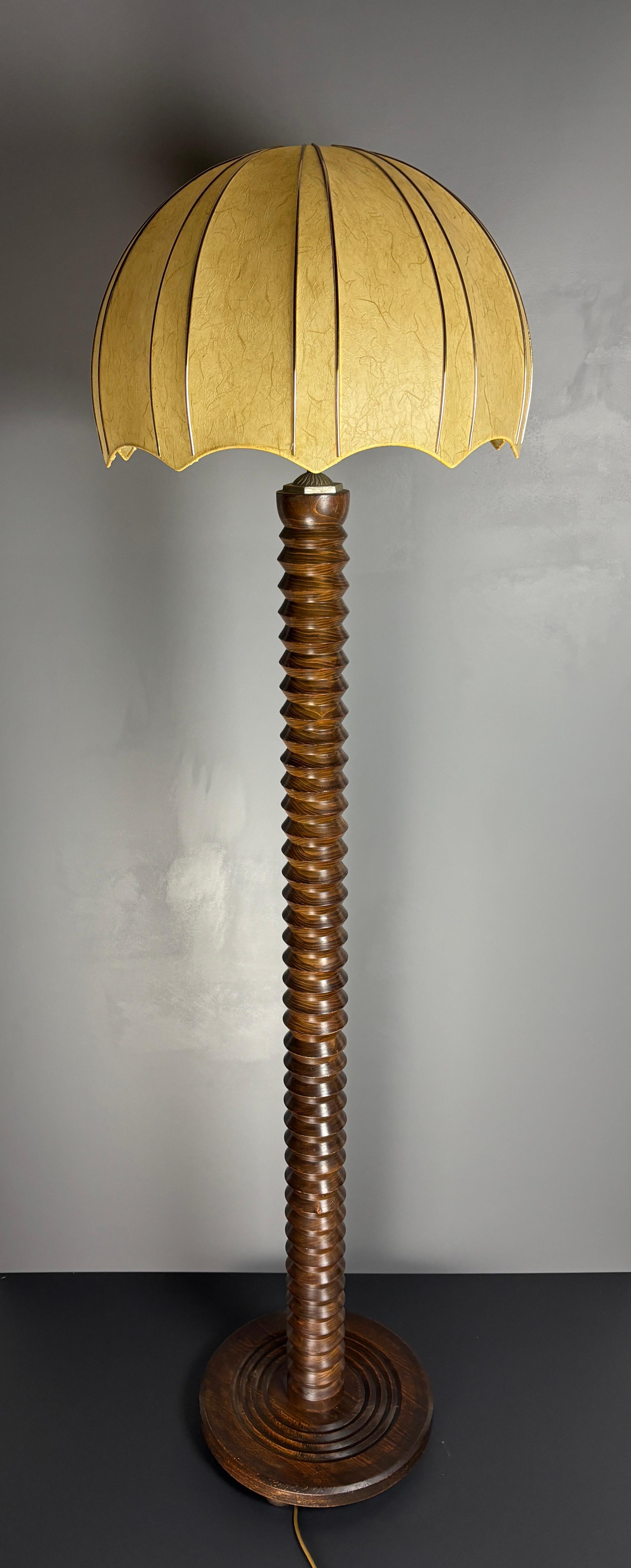 Atemberaubende Stehlampe aus gedrechseltem Holz im Stil von Charles Dudouyt, 1950er Jahre, mit einem Kokon-Pilz-Schirm (spätere Ergänzung und wahrscheinlich 1960er- 1970er-Jahre). Der Lampensockel ist in gutem Zustand, die Lampe wurde neu verkabelt