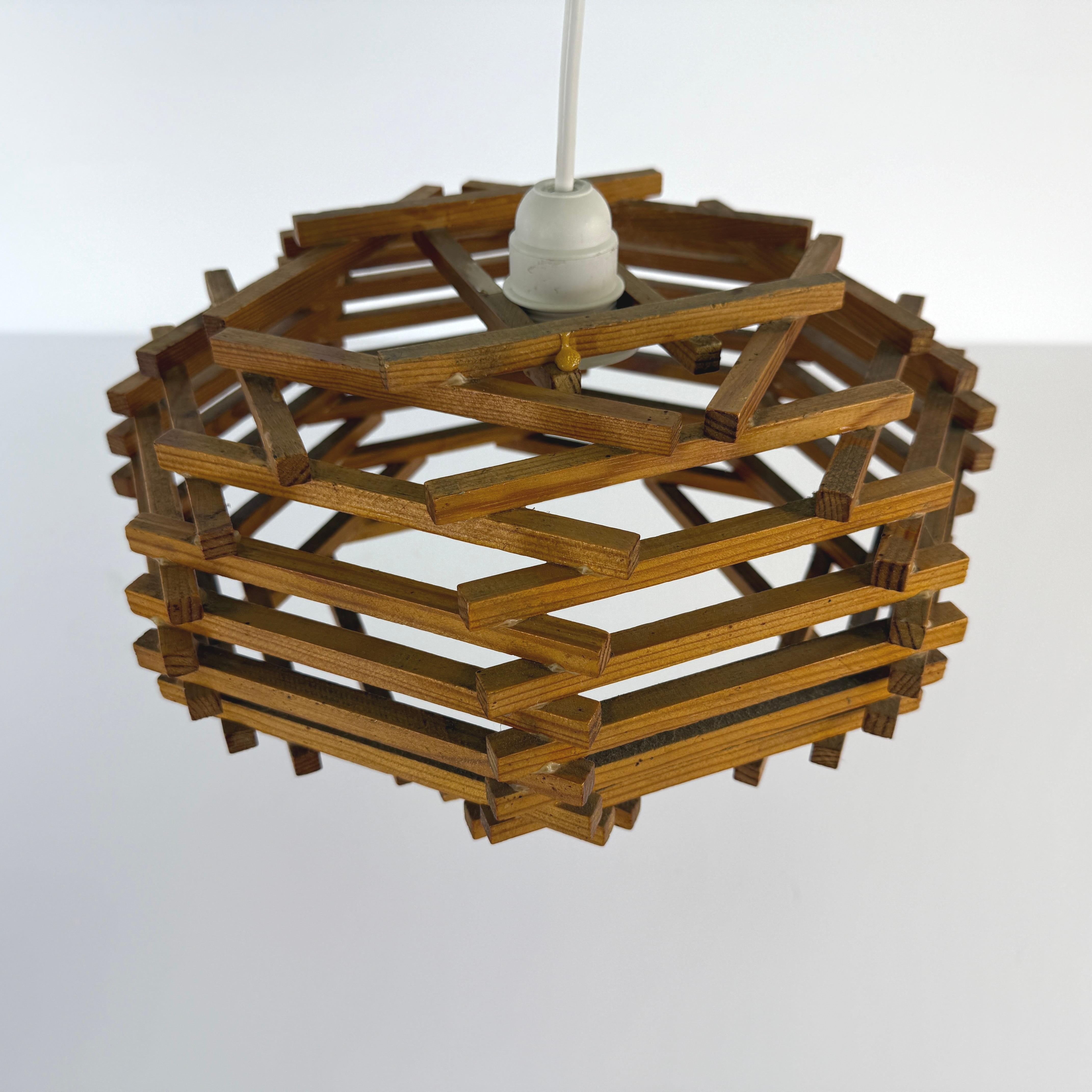 Dimensions: H 7.5” x W 13”

Brutalist wood slat pendant lamp, manufactured in France in the 1950s with one light inside.

Please see our other listings for ideas and matching pieces.

Condition: Vintage condition consistent with age. Please observe