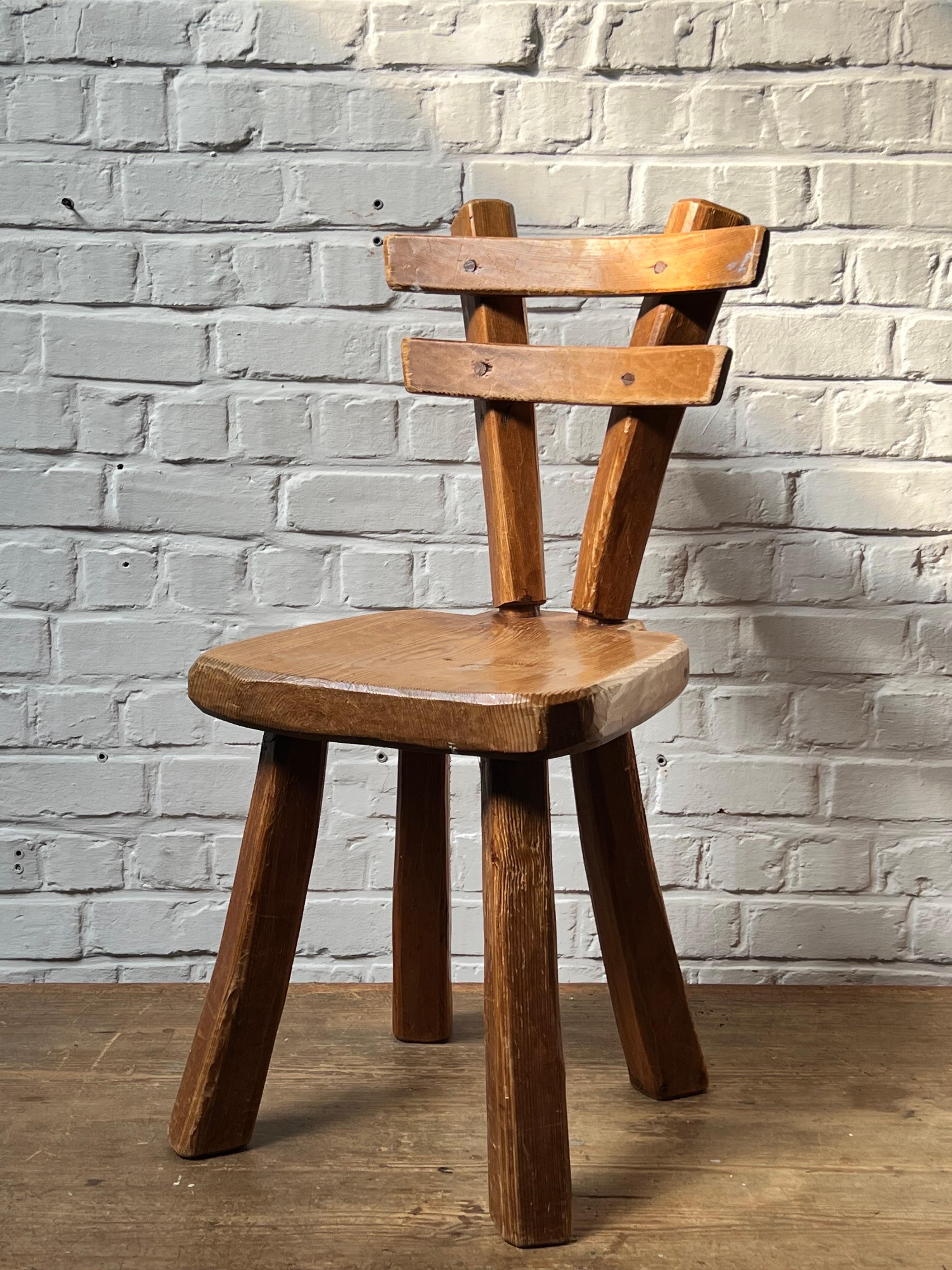 Very unique handmade with massive pine . The joinery is two cylinder which provide a nice effect. The overall is patinated and shows various shades of brown/brownish colors. Elegant and brutalist describe that chair properly. Very strong chair. We