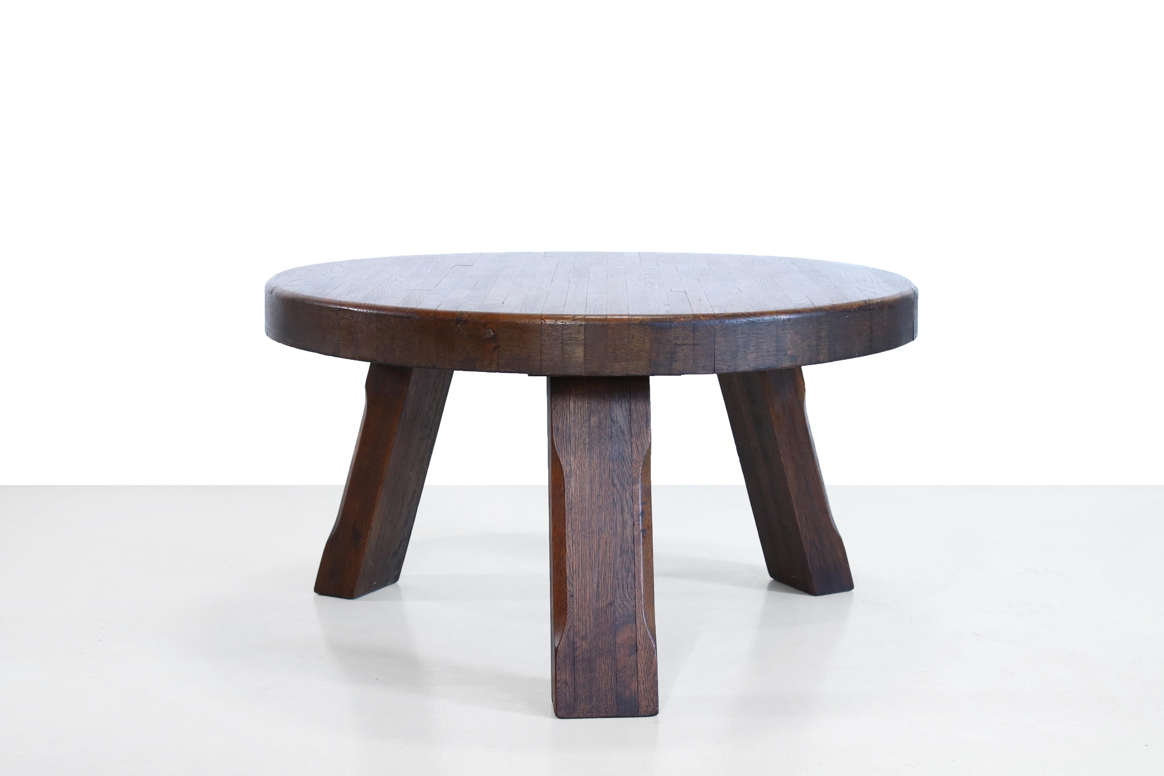 Brutalistic round coffee table from France. Handmade from solid heavy oak wood. The table stands on three legs. The table has a diameter of 80 cm and is 45 cm high.