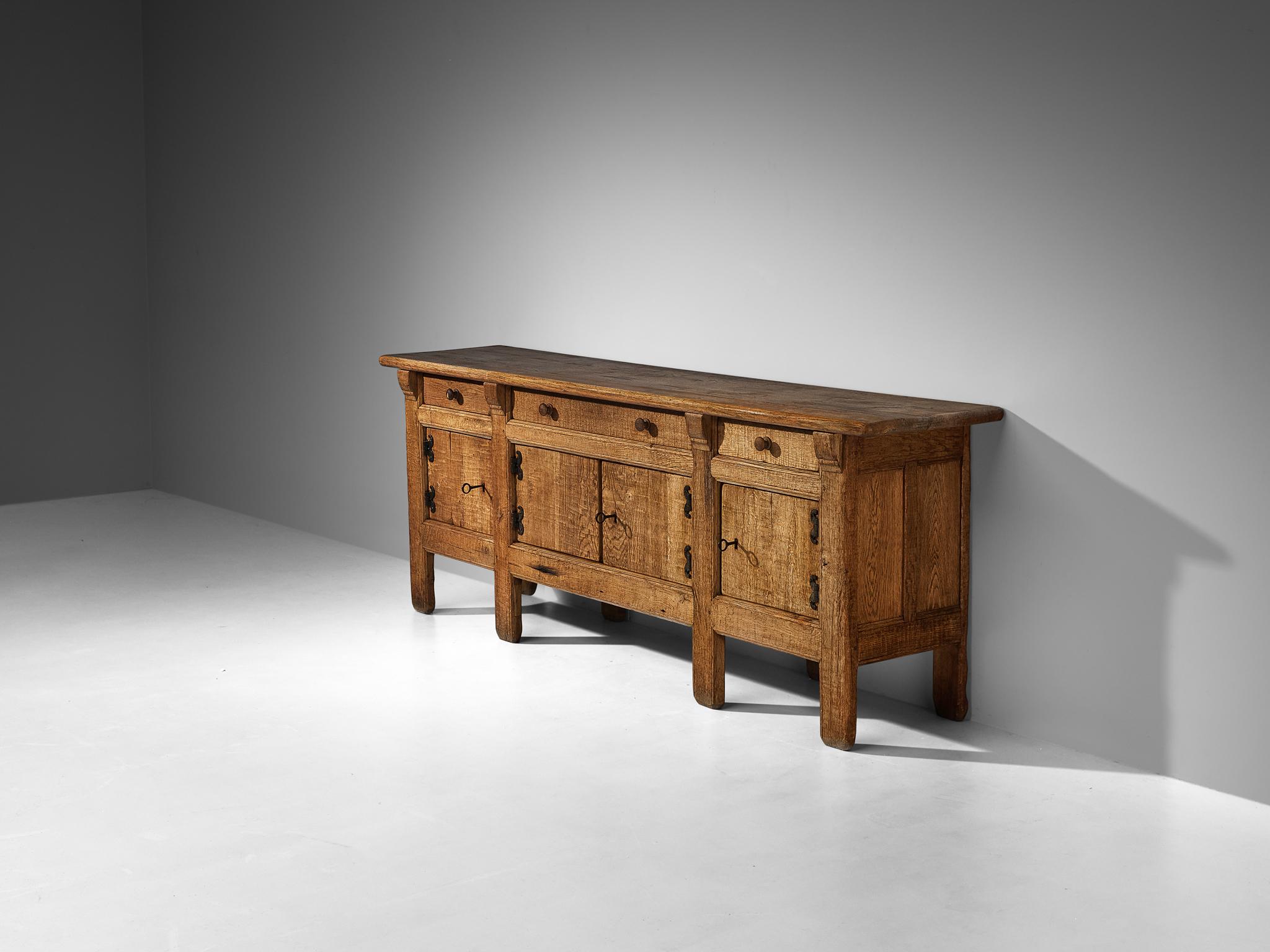 Sideboard, oak, iron, France, 1960s

This credenza is made in France around the 1960s and beautifully reflects the stylistic traits of Brutalism. A solid construction executed in solid oak where clear lines and sturdy shapes are allowed to emerge in