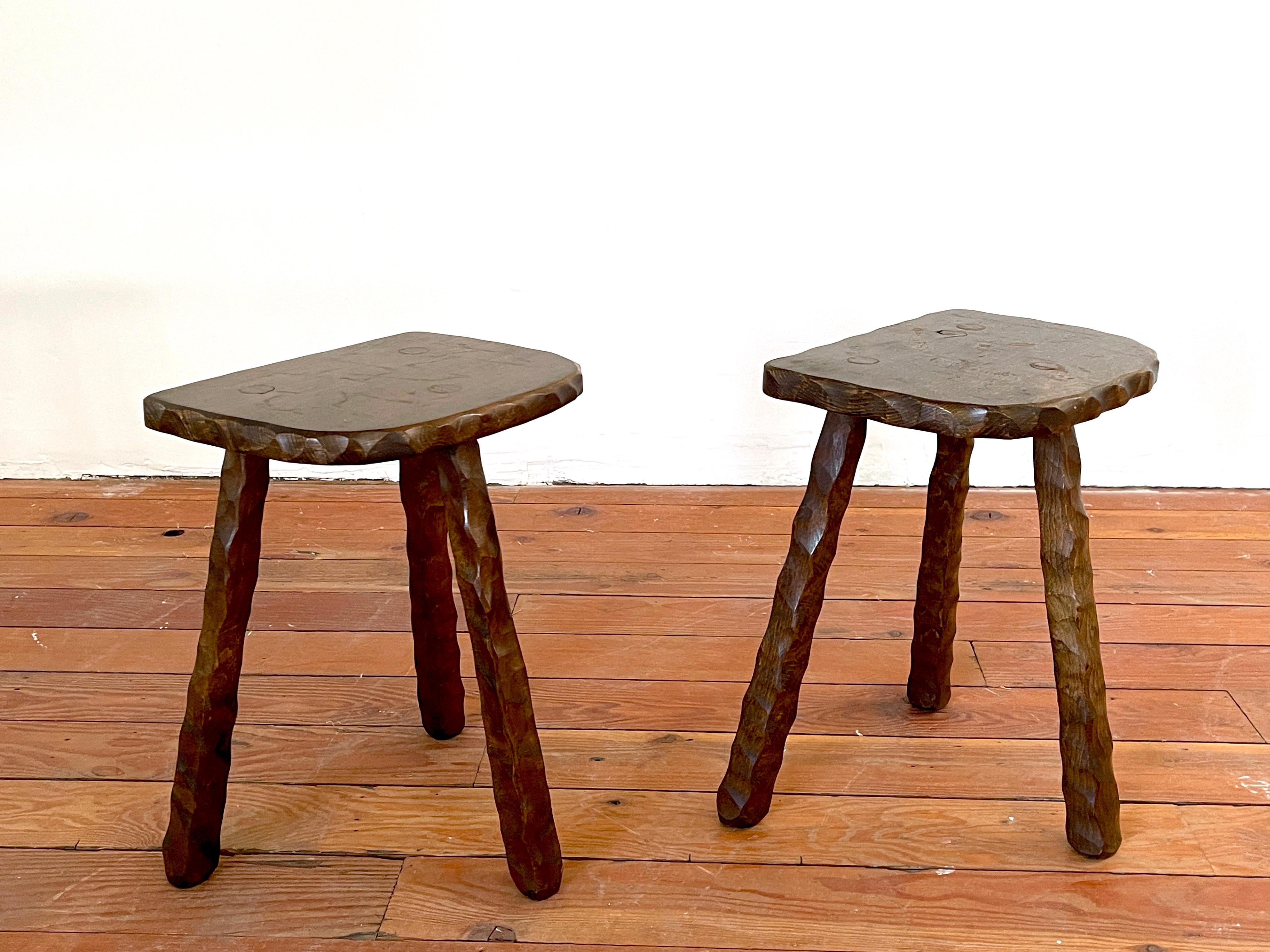 Pair of French brutalist stools with hand carved legs and great patina.