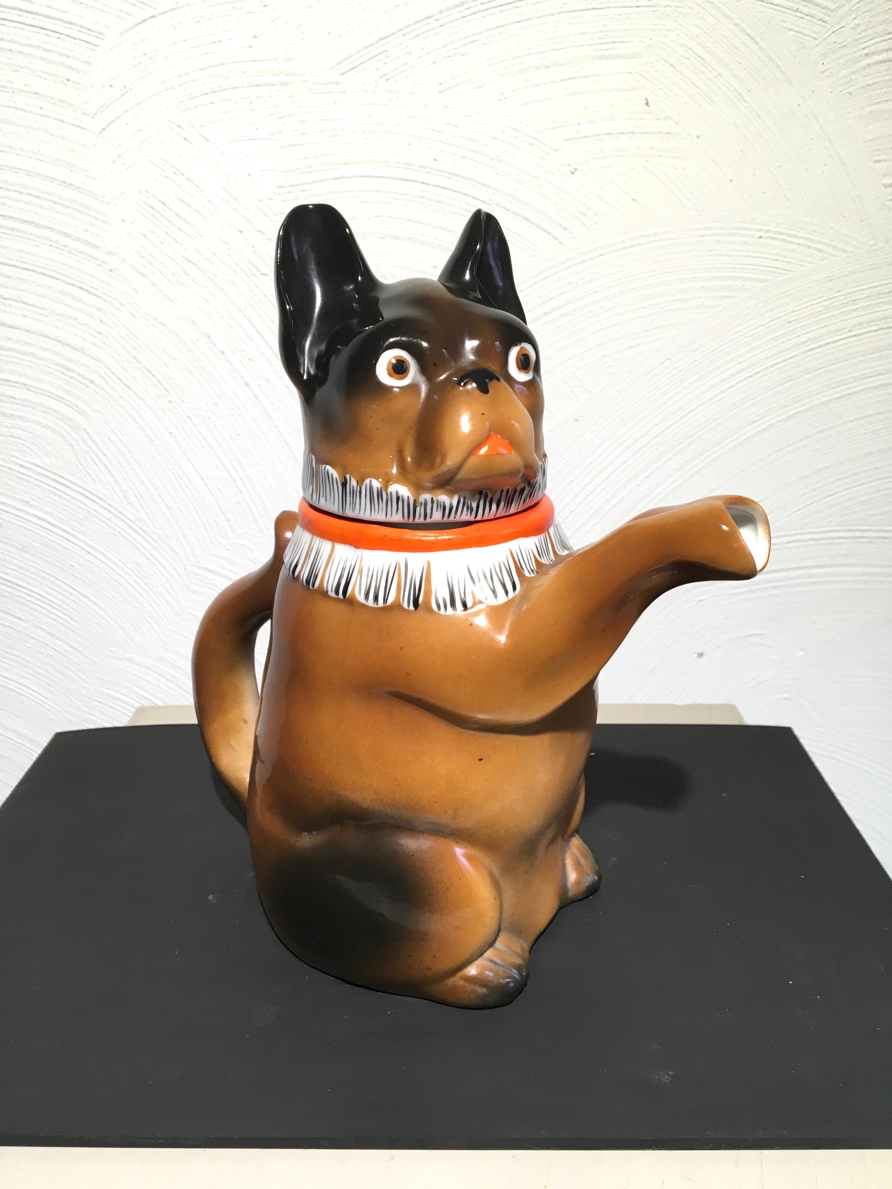 Art Deco Bulldog Teapot. 
French Bulldog Teapot - Jug - Pitcher from the 1930s.
A brown with dark brown French bulldog sculpture with a white and orange collar which has even the look of a badger collar. 
This Frenchie is sitting and has beautiful