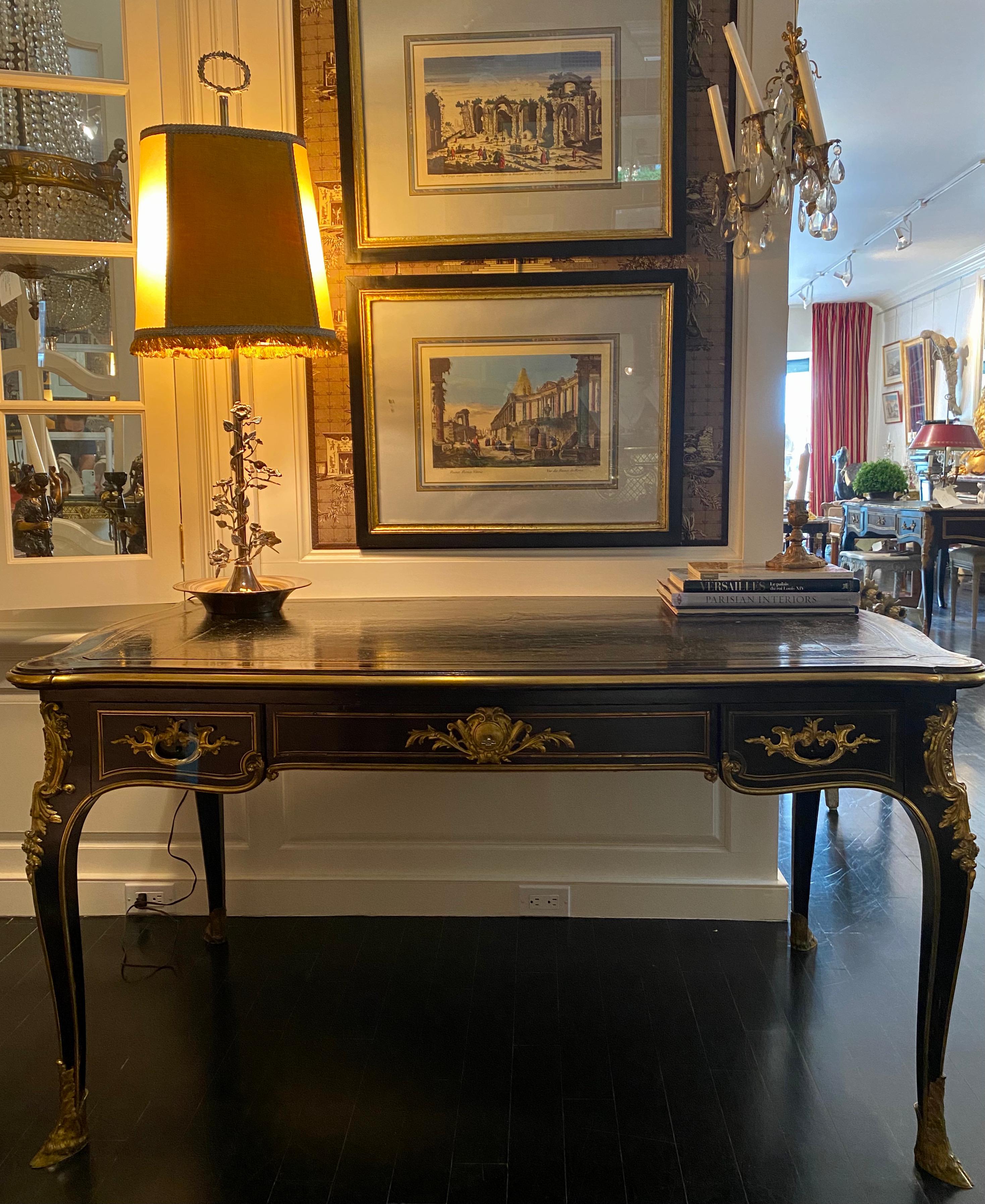 French ebonized Napoleon III period, Louis XV style bureau plat. Bronze sabot feet, tapered legs. Beautiful gilt bronze details. Three-drawer desk with insert pull-out slide writing surfaces on each side. Patinated black gilt tooled leather top.