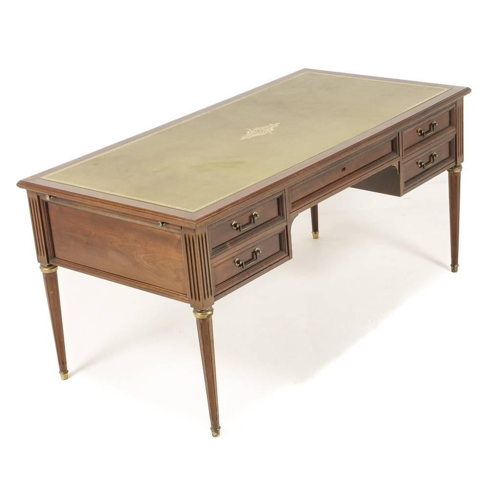 A vintage French mahogany-and-leather Louis XVI-style ‘Bureau Plat’ desk, with leather top and pull-out platforms at each end, circa 1950.

