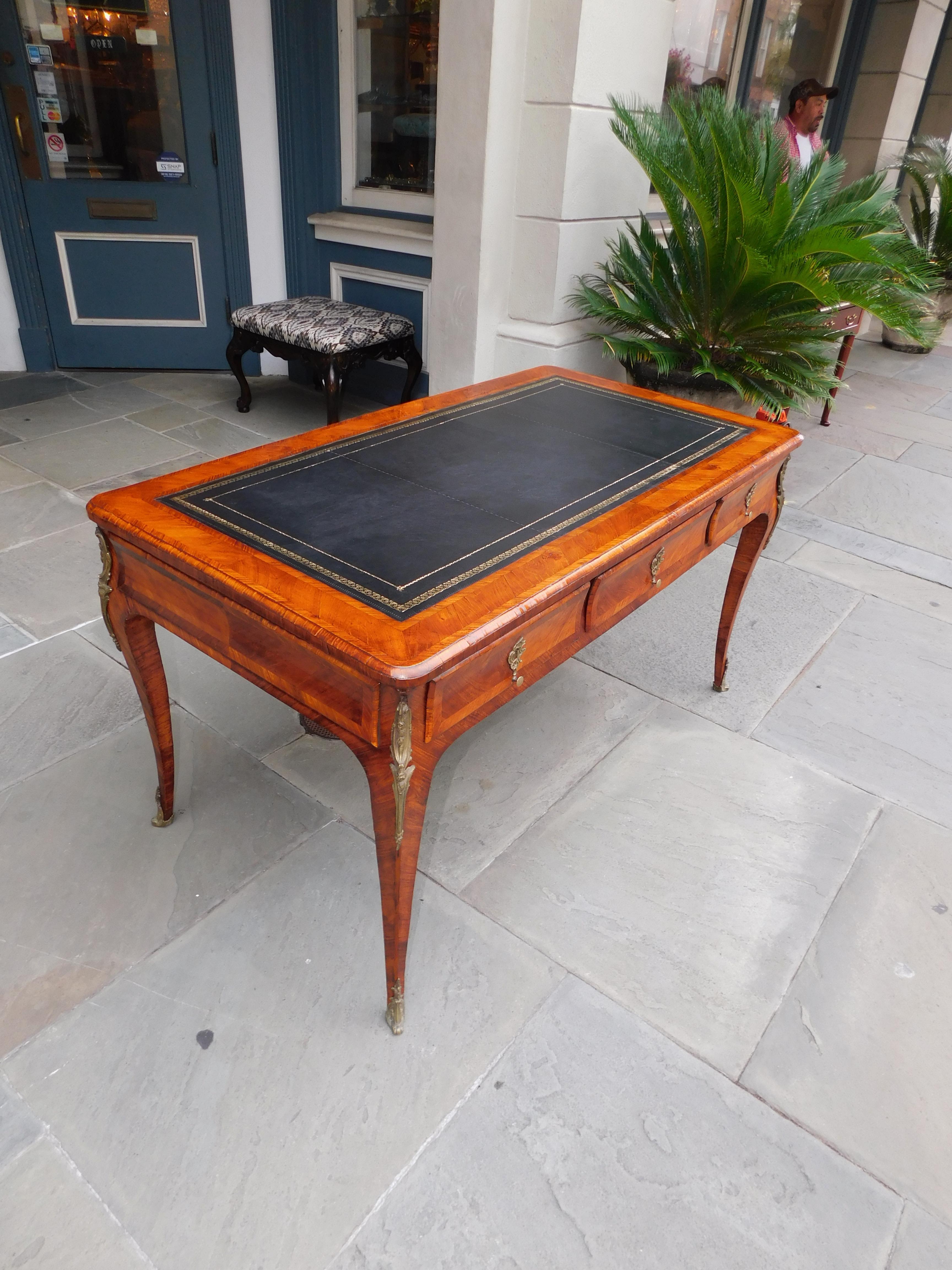 French bureau plat marquetry leather top three drawer desk with hearing bone inlays, three opposite side faux drawers, original floral ormolu mounts, brass escutcheons, brass knobs, and resting on the original cabriole legs. Late 18th century. Skirt