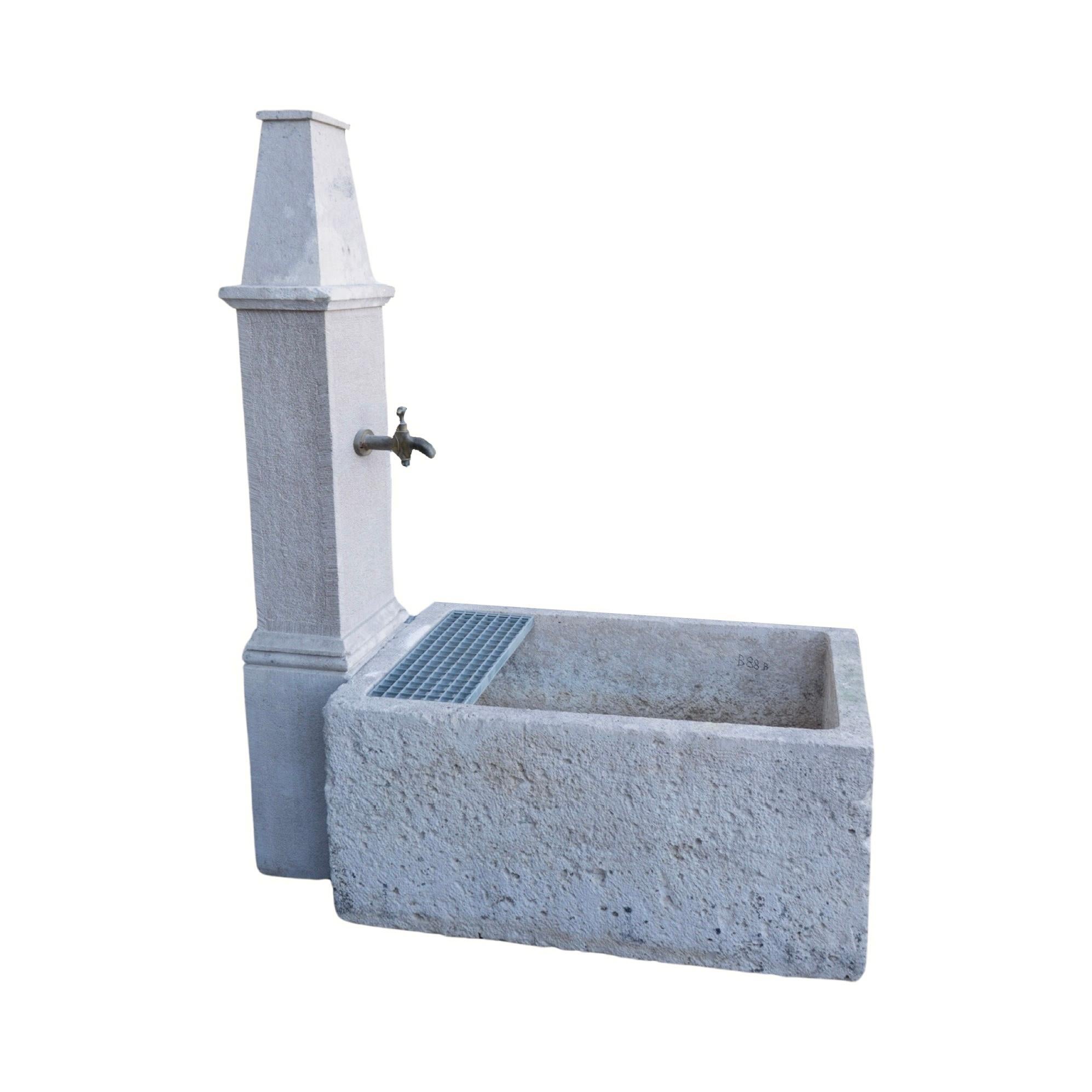 Handcarved in the South of France, this 1880s French Burgundy Limestone Wall Fountain brings elegance to any outdoor space. The trough style basin and antique bronze spout provide a classic touch, while the water bucket ledge allows for easy