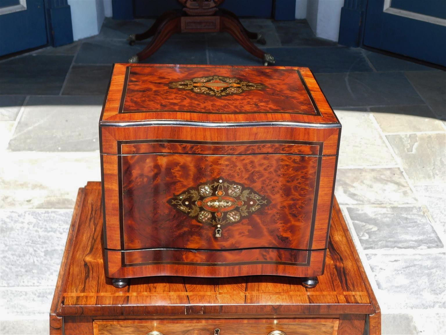 French burl walnut ebony, brass, and mother of pearl inlaid Tantalus with hinged folding top, flanking hinged sides, cross banded tulip wood, original locking mechanism with key, fitted interior with gilt crystal bar ware carrier, and resting on the