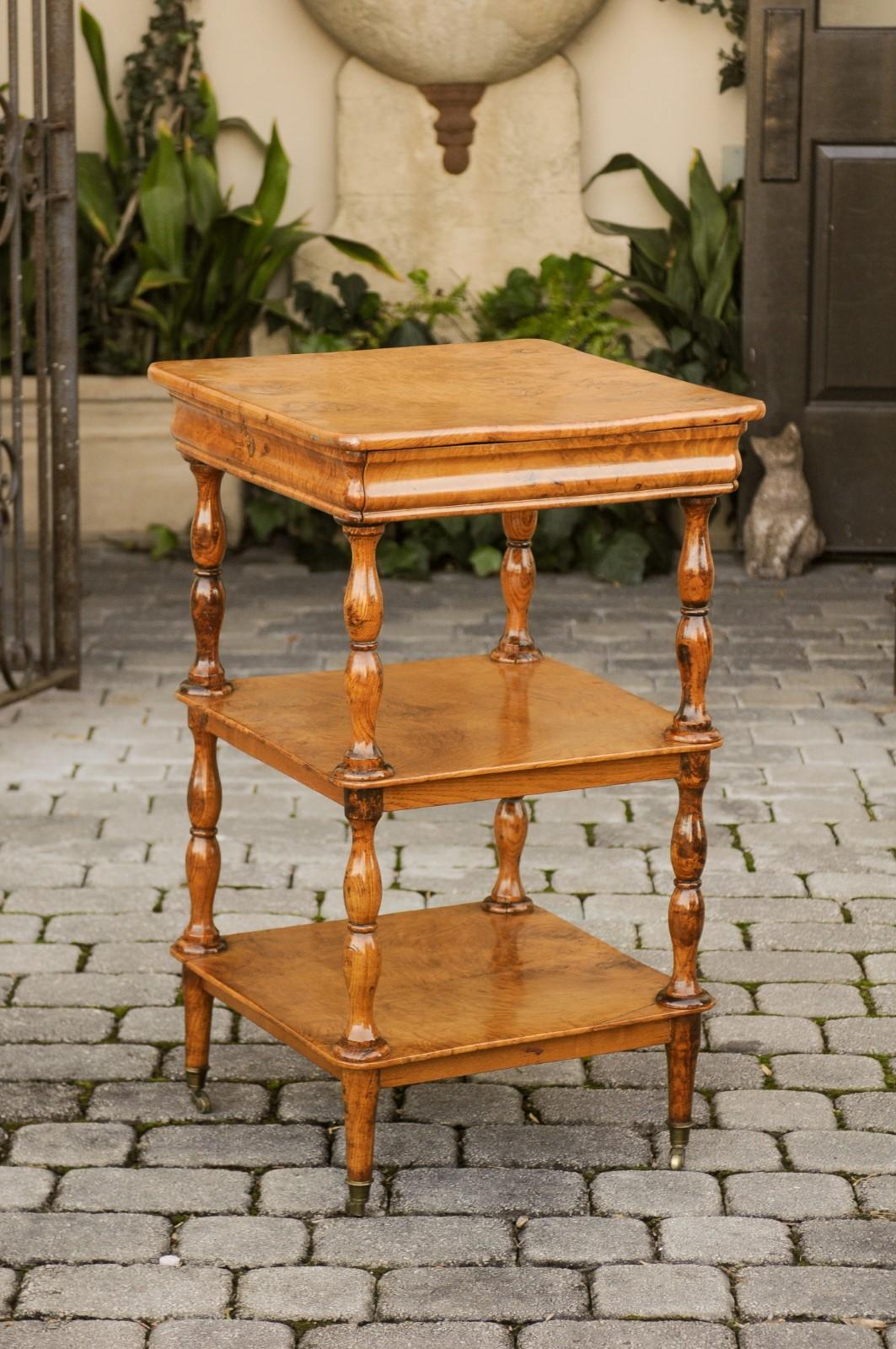 A French burl walnut tiered trolley from the late 19th century, with butterfly veneer, single drawer, turned legs and cavetto molding. Born in the third quarter of the 19th century at the end of the reign of Emperor Napoleon III, this tiered trolley
