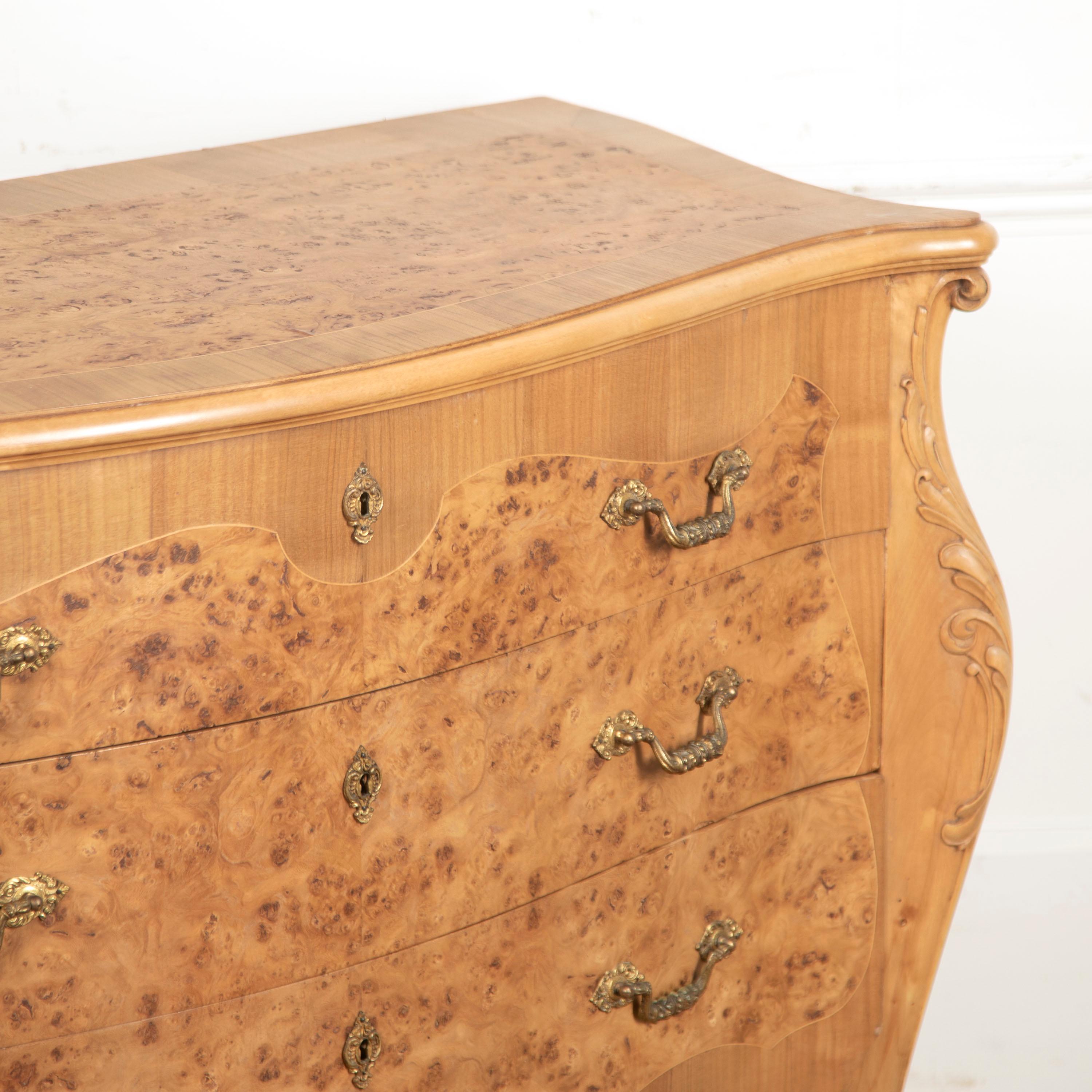 Pretty French burr walnut boule commode dating to the early 20th Century.

This commode has a fantastic form. It has stunning graining and colour throughout which are highlighted by the golden walnut undertones. 

The whole terminates onto