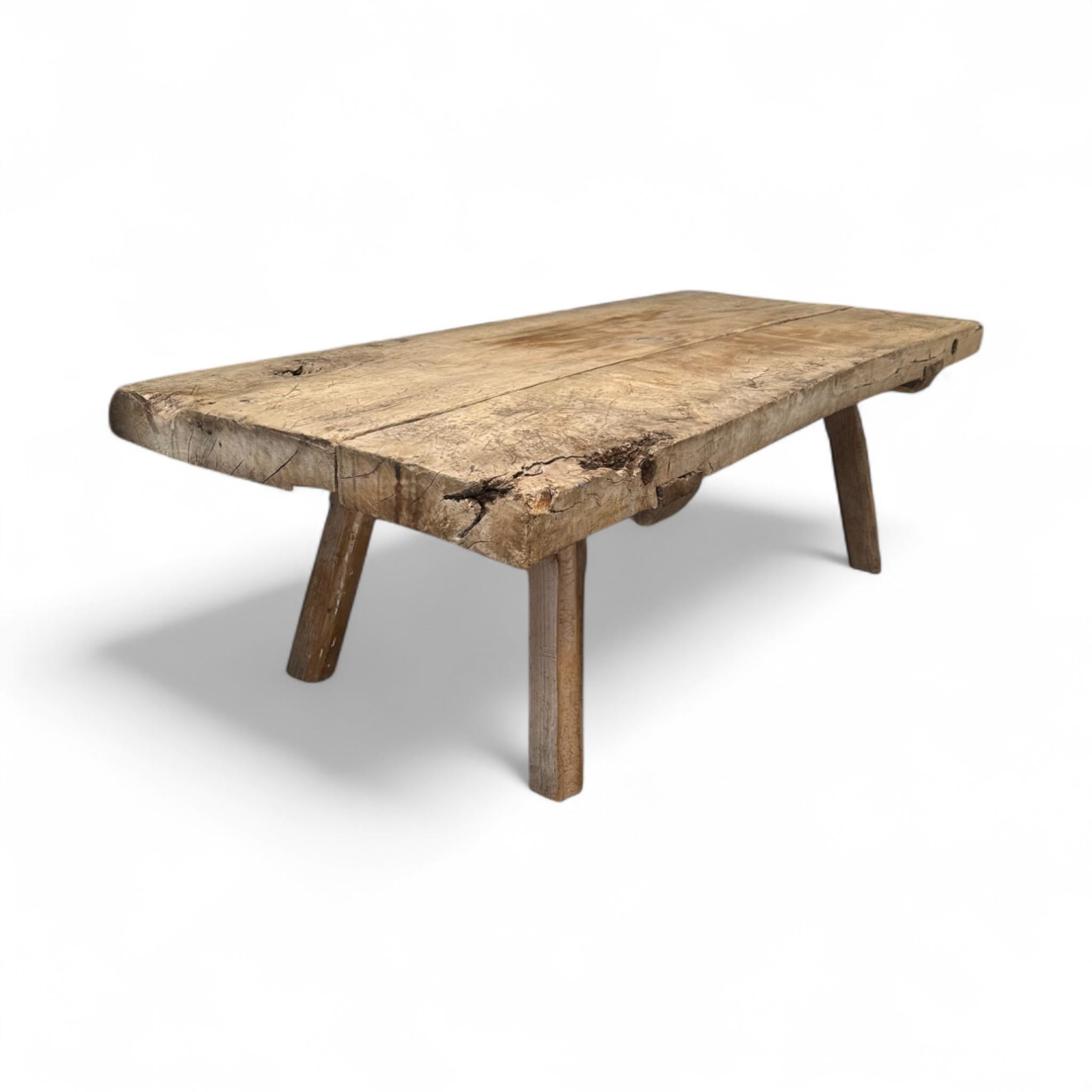 This rustic French butcher block coffee table features a beautifully aged wood top with natural imperfections and character that tell its story. The simple, sturdy legs and raw finish make it a perfect fit for farmhouse, bohemian, or