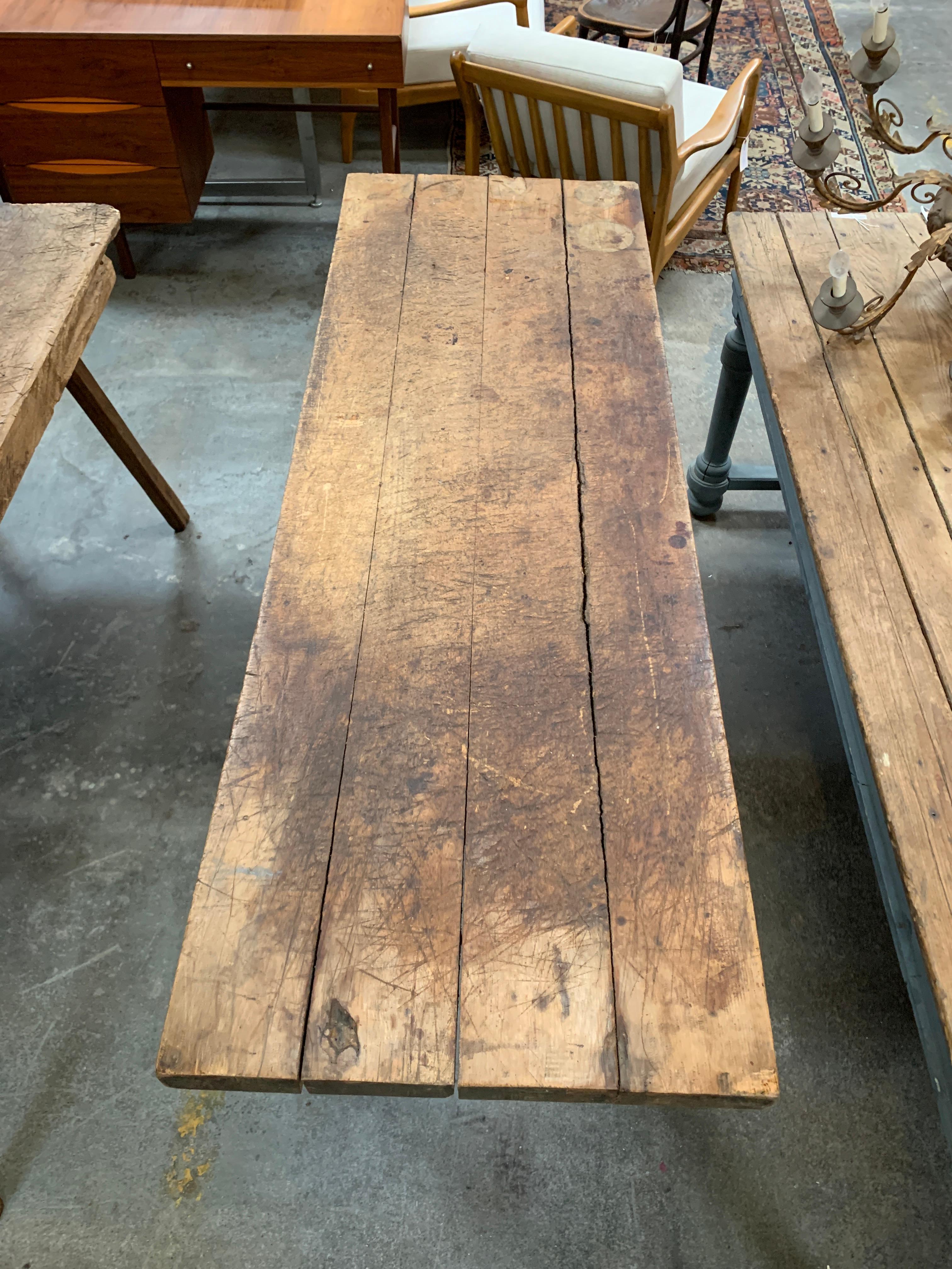 This French butcher block table is in great original condition. It has sturdy wooden legs and a beautifully worn in table top, with structural metal accents along the length of the table.