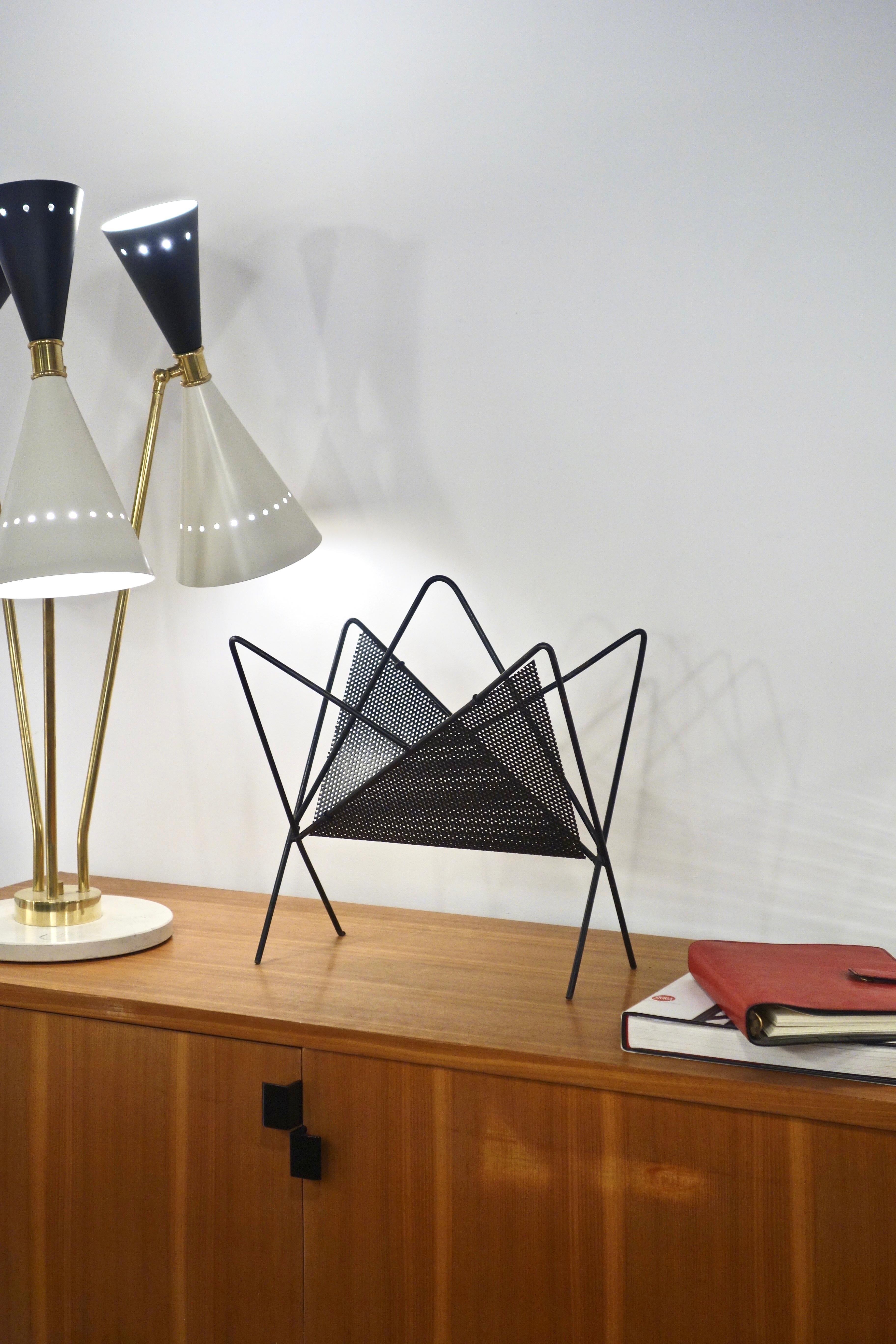 “Butterfly” magazine rack by Mathieu Matégot dating from 1954. French manufacturing by Ateliers Matégot. Geometric model in black lacquered steel rods and perforated sheet metal. Item in its original condition, patinated, with its traces of time (It