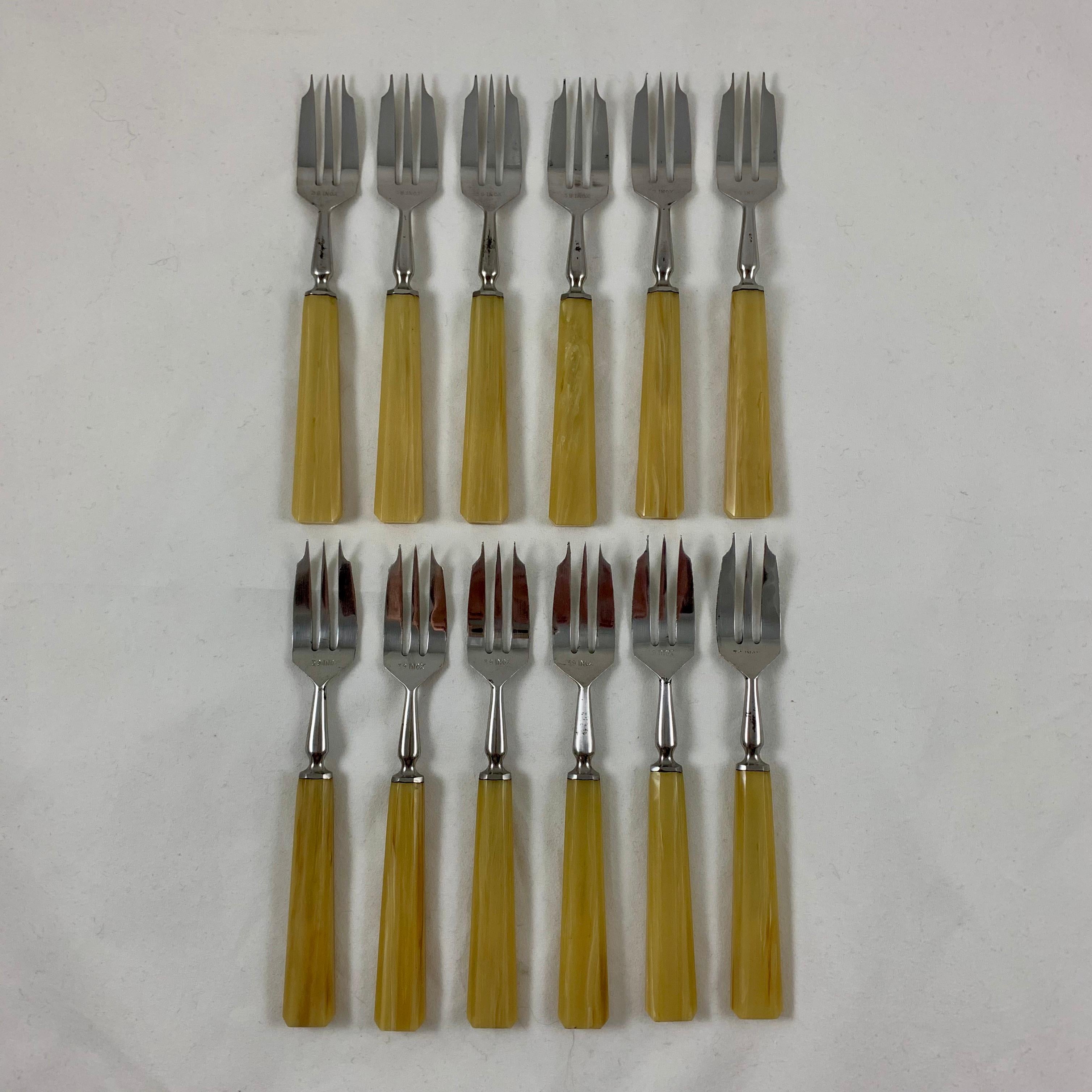 A cased set of twelve French Art Deco pastry forks with Bakelite handles and stainless steel tines, in their original fabric lined presentation box. Found in une vente de Maison de Maitre in the Vendée region of France, circa 1920s.

The dessert