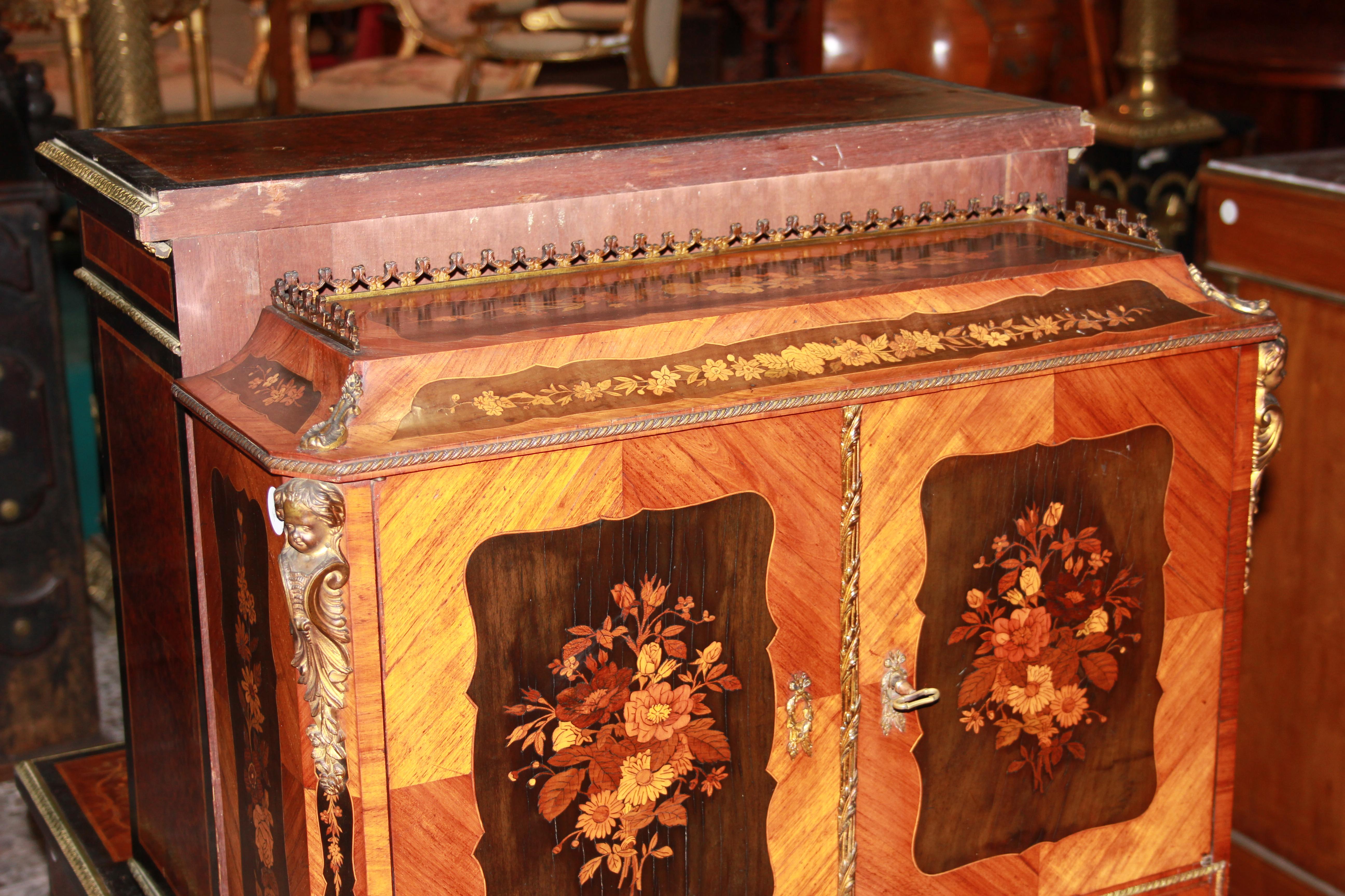 French credenza cabinet from the first half of the 1800s, Louis XV style, made of rosewood and ebony richly inlaid. It features an upper body with a top perimeter bordered by brass railing, 2 closed doors, and bronze caryatids. The lower body
