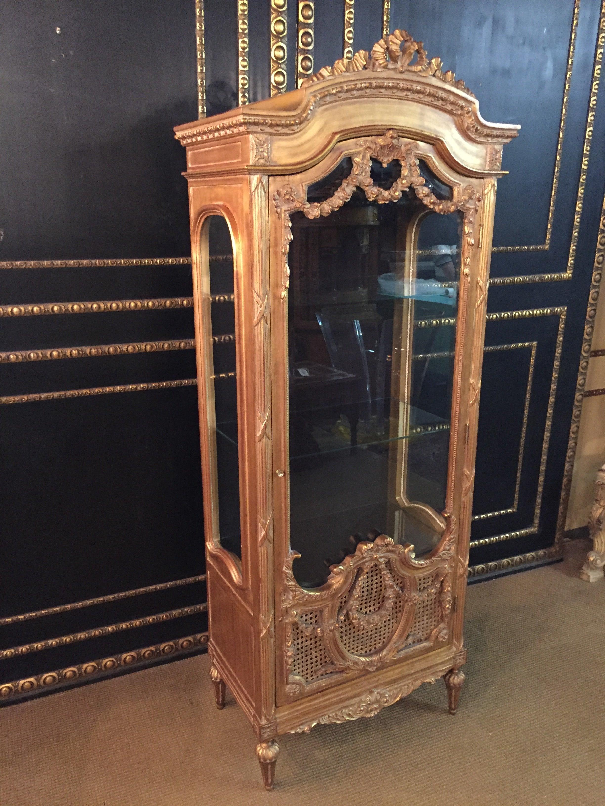 French cabinet in Louis Seize style

Solid beech, gilded. Rectangular, three-sided, faceted beveled, one-door body on conical legs. The door is partially provided with wickerwork. The front, corners and sides are decorated with carved, Classic