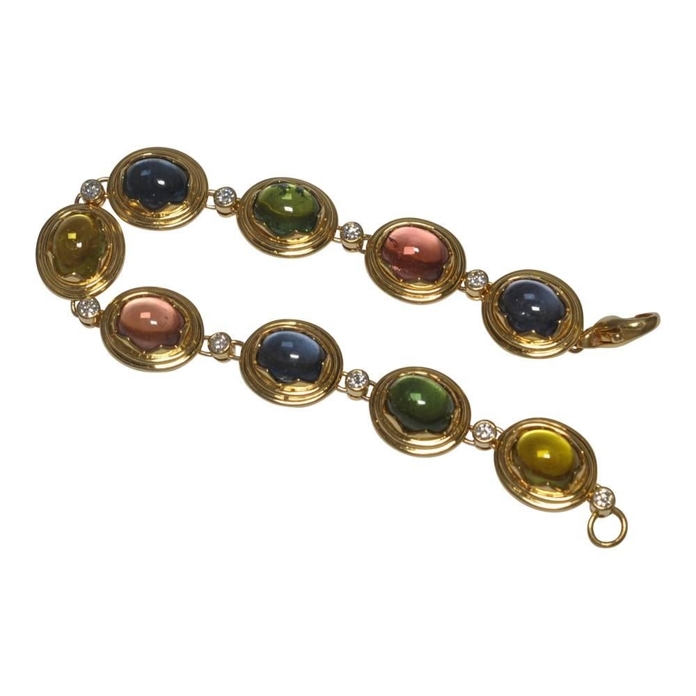 French multi coloured cabochon tourmaline and diamond bracelet; formed of oval stones each set in a gold pointed scolloped mount creating a star shape and  linked by brilliant cut diamonds.  The 9 tourmalines are in pastel shades of pale blue,