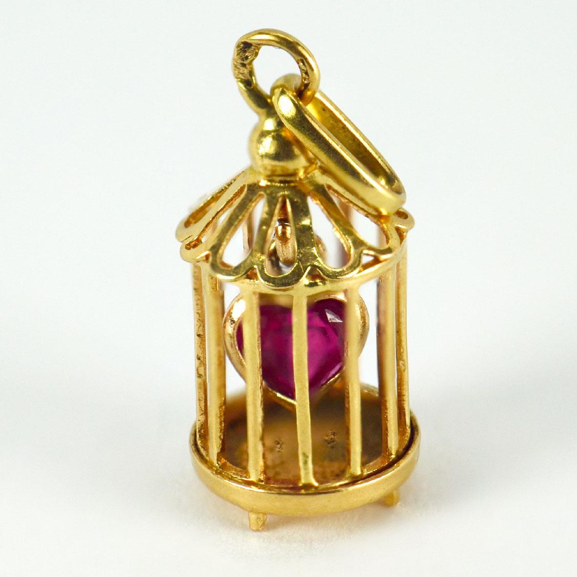 An 18 karat (18K) yellow gold charm pendant designed as a caged red synthetic ruby heart. Stamped with the eagle’s head for French manufacture and 18 karat gold.

Dimensions: 2 x 0.85 x 0.85 cm (not including jump ring)
Weight: 1.53 gram
