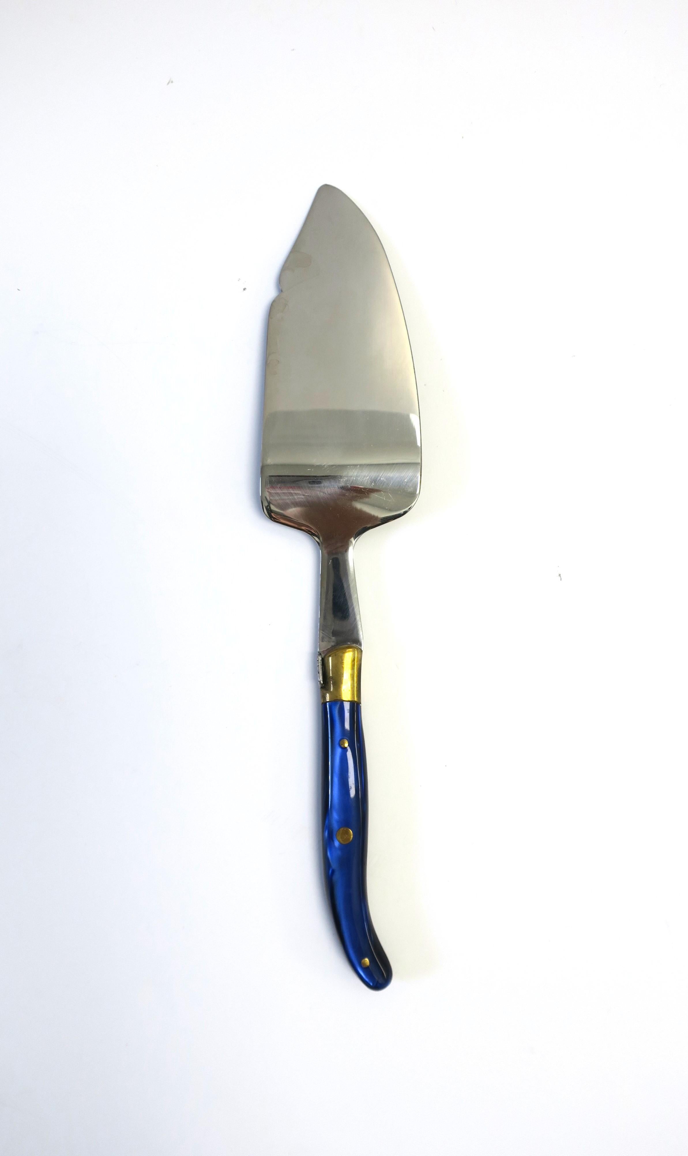 A well-made French cake tart pastry knife cutlery utensil and serving piece by Claude Dozorme, circa late 20th to early 21st century, France. Piece is stainless steel, brass, and finished with a resin cobalt blue handle. Made in France. Piece has