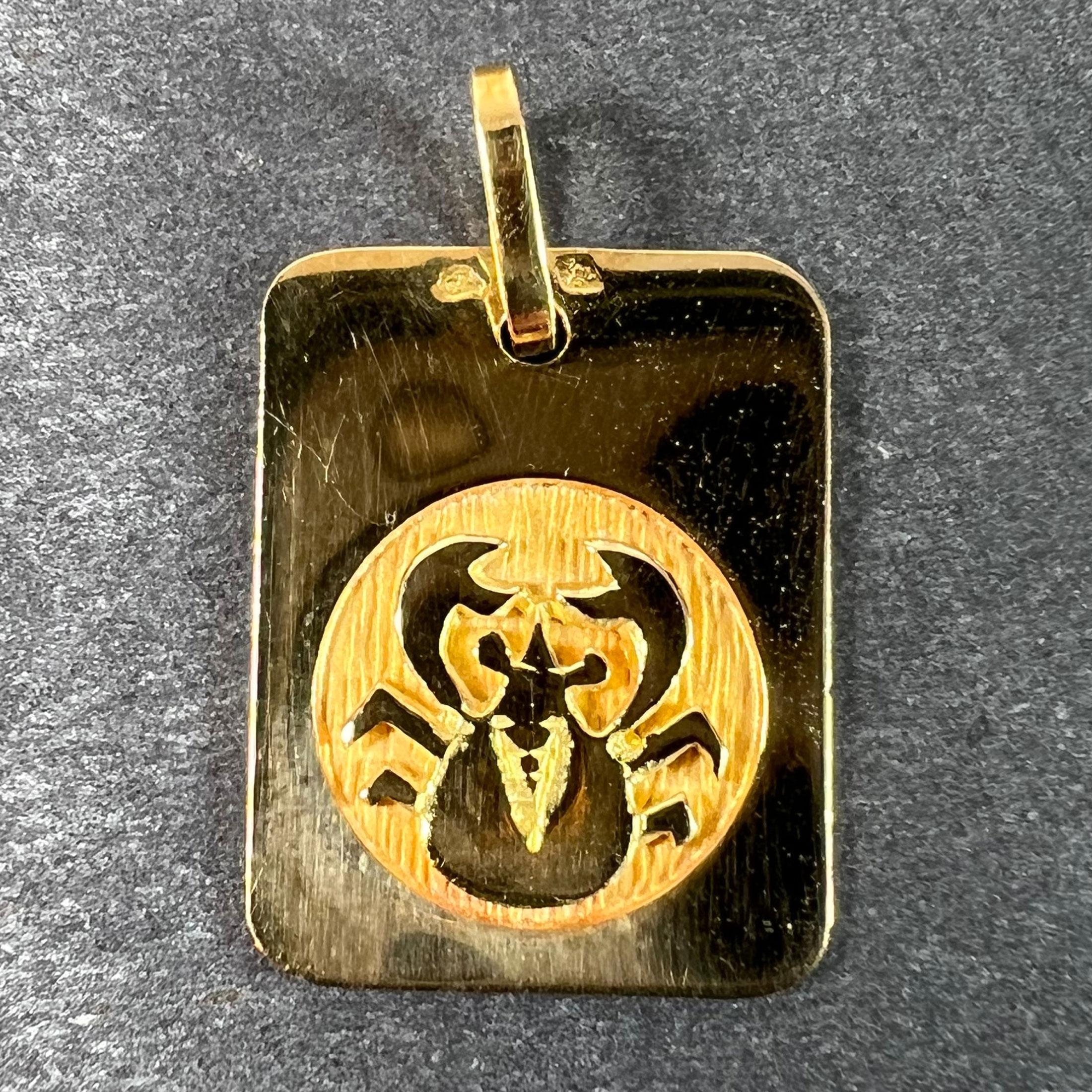Pendentif de charme français en or jaune 18 carats (18K) conçu comme une médaille rectangulaire avec un renfoncement circulaire gravé représentant un crabe représentant le signe astrologique zodiacal du Cancer. Estampillé de la tête d'aigle pour la