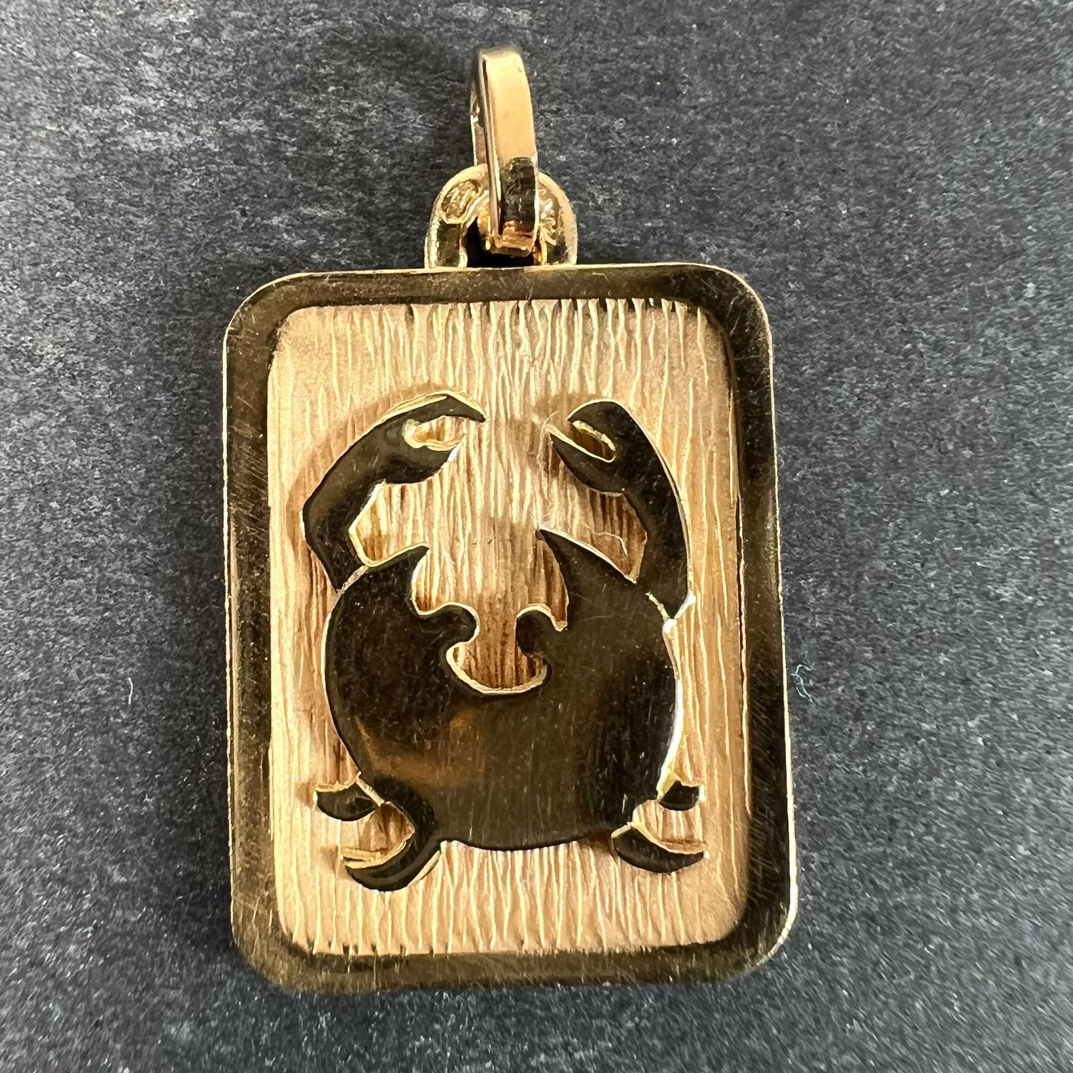 Un ciondolo francese in oro giallo 18 carati (18K) disegnato come una medaglia rettangolare con un incavo inciso raffigurante un granchio che rappresenta il segno zodiacale del Cancro. Timbro a testa d'aquila per la manifattura francese e oro a 18