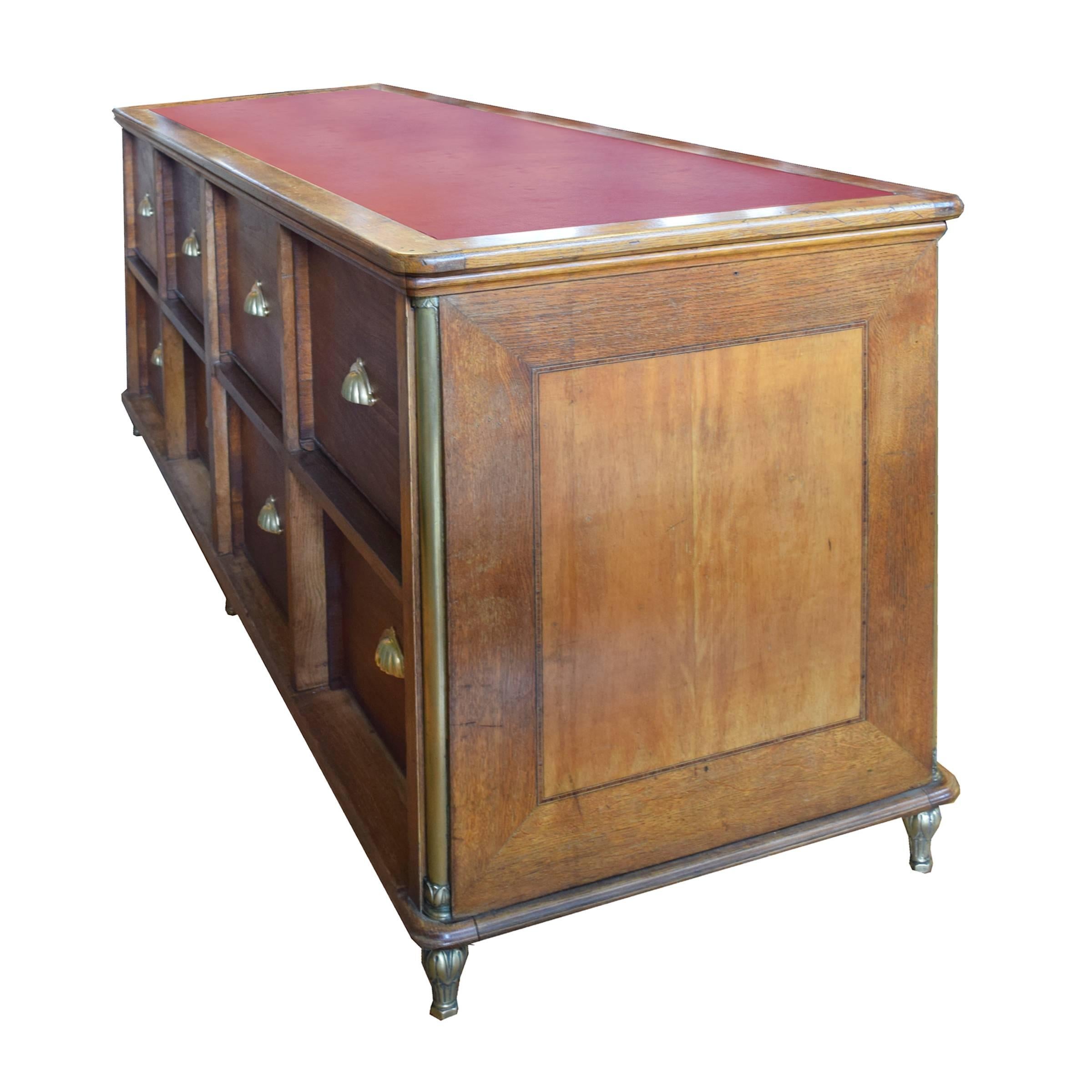 A fantastic French candy shop display counter with eight drawers, brass fittings, and a great red leather top, circa 1920.