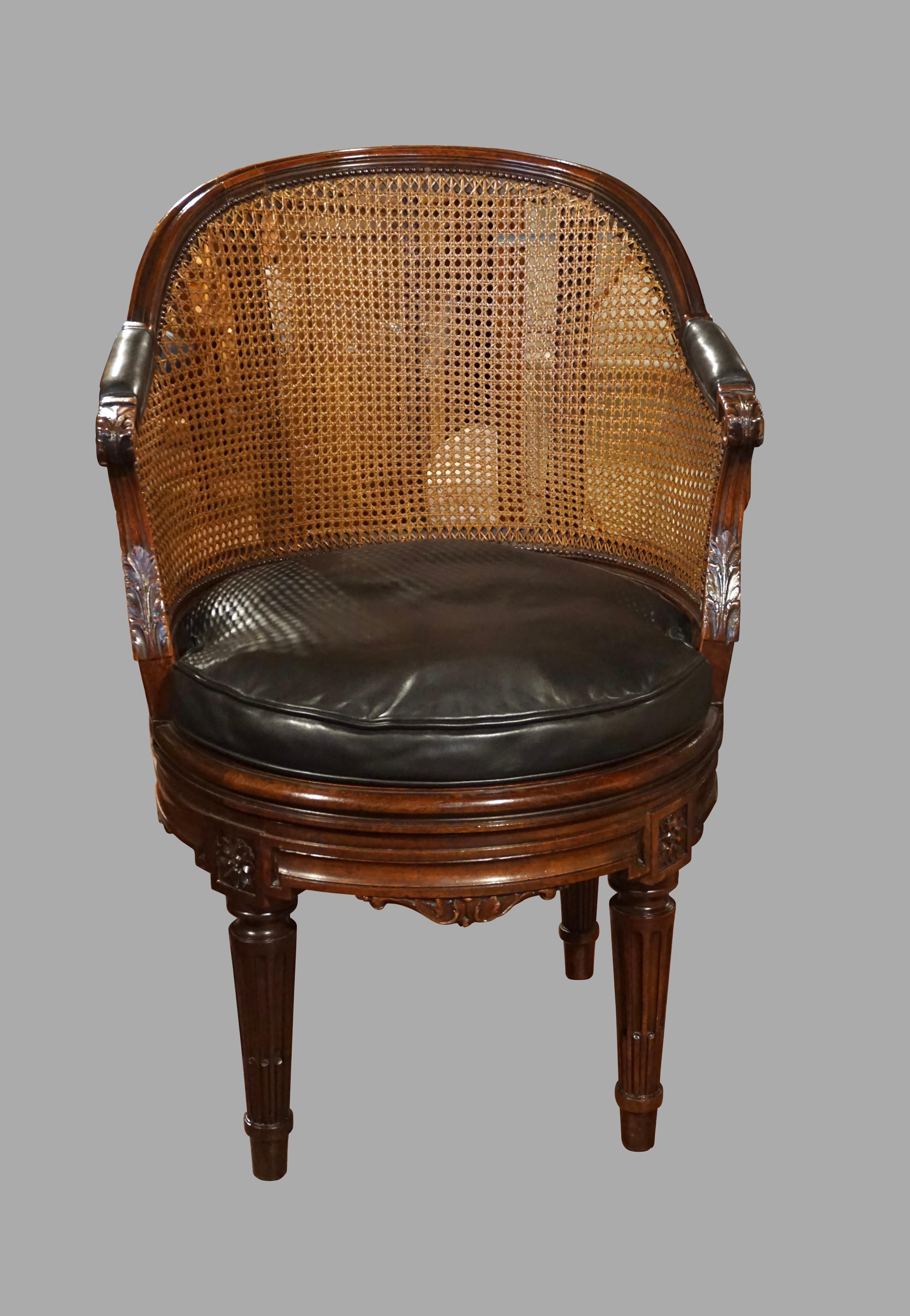 A stylish and very well-made French Louis XVI style mahogany armchair, the caned seat and back in excellent condition, the seat with a dark green leather cushion. This is a wonderful and quite comfortable swivel desk chair with a curved back and