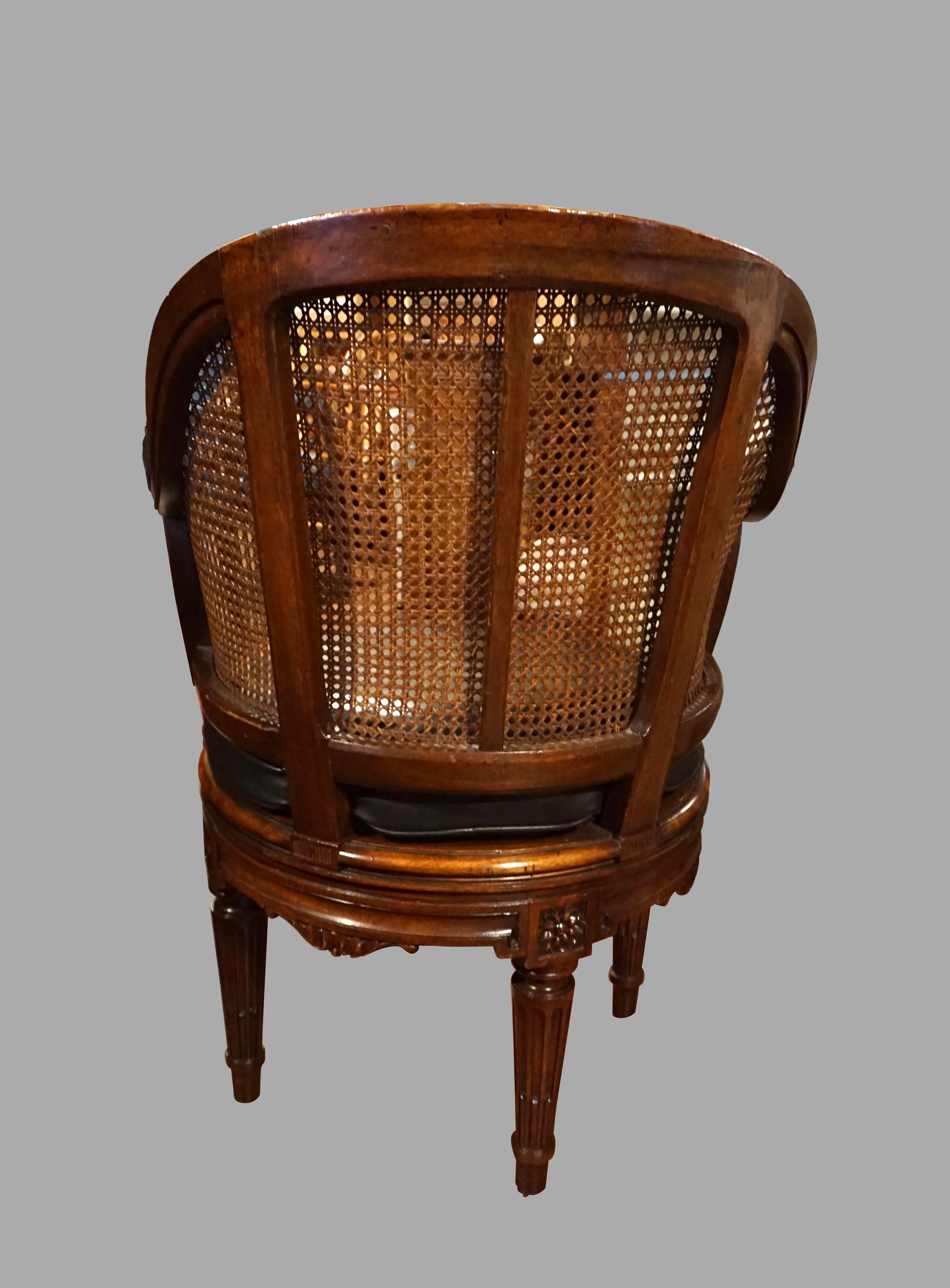 20th Century French Caned Louis XVI Style Carved Walnut Swivel Desk Chair with Leather Seat