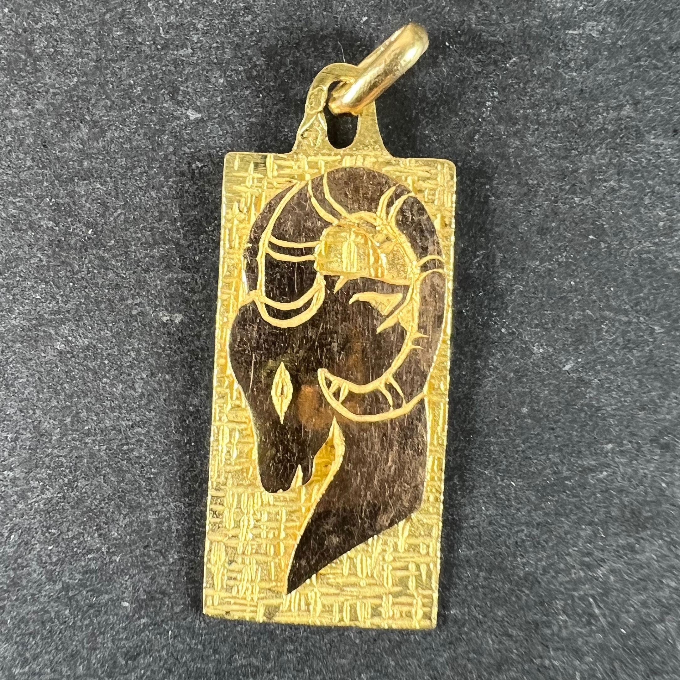 Pendentif de charme français en or jaune 18 carats (18K) conçu comme une médaille rectangulaire représentant la tête d'un bélier ou d'une chèvre avec un fond en retrait et gravé, représentant le signe astrologique zodiacal d'Arès ou du Capricorne.
