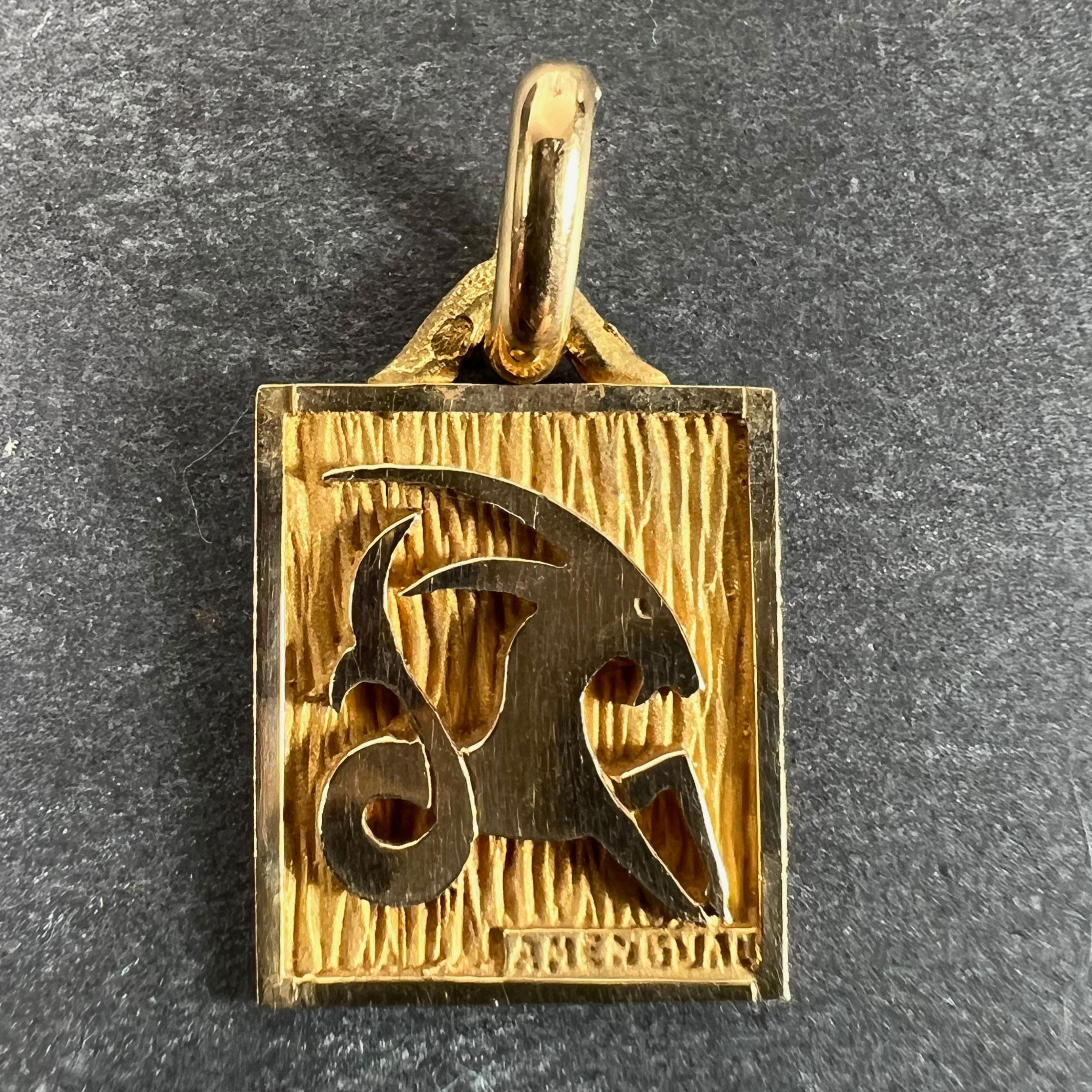 A French 18 karat (18K) yellow gold charm pendant designed as a rectangular medal with an engraved recess depicting a goat-fish hybrid representing the zodiac star sign of Capricorn. Stamped with the eagle’s head for French manufacture and 18 karat