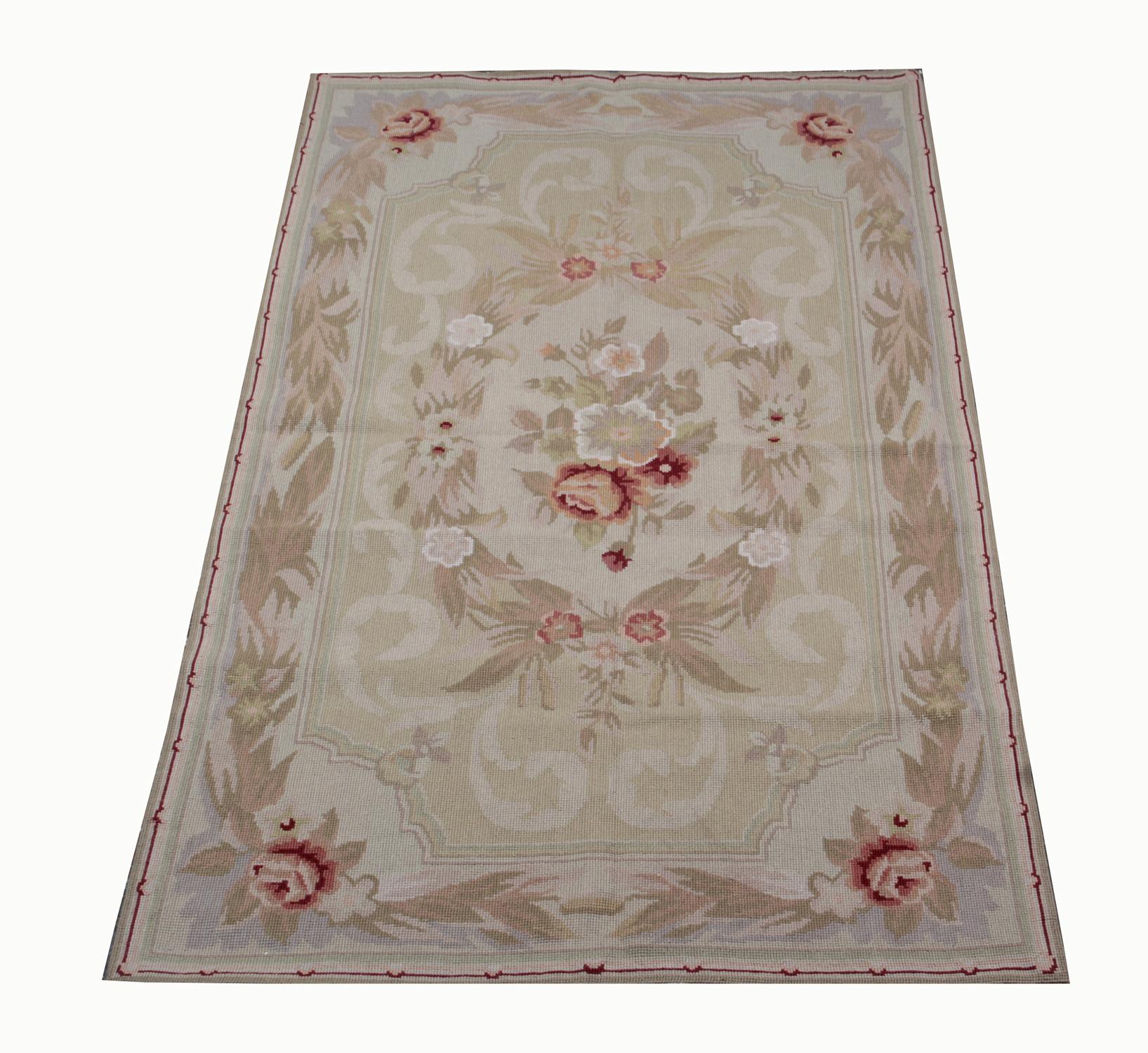 This floral needlepoint rug has been woven with a subtle cream background, decorated with asymmetrical ornate design with pink floral details and foliate scrolls in both the centre and border. The color and design both sit in harmony creating a