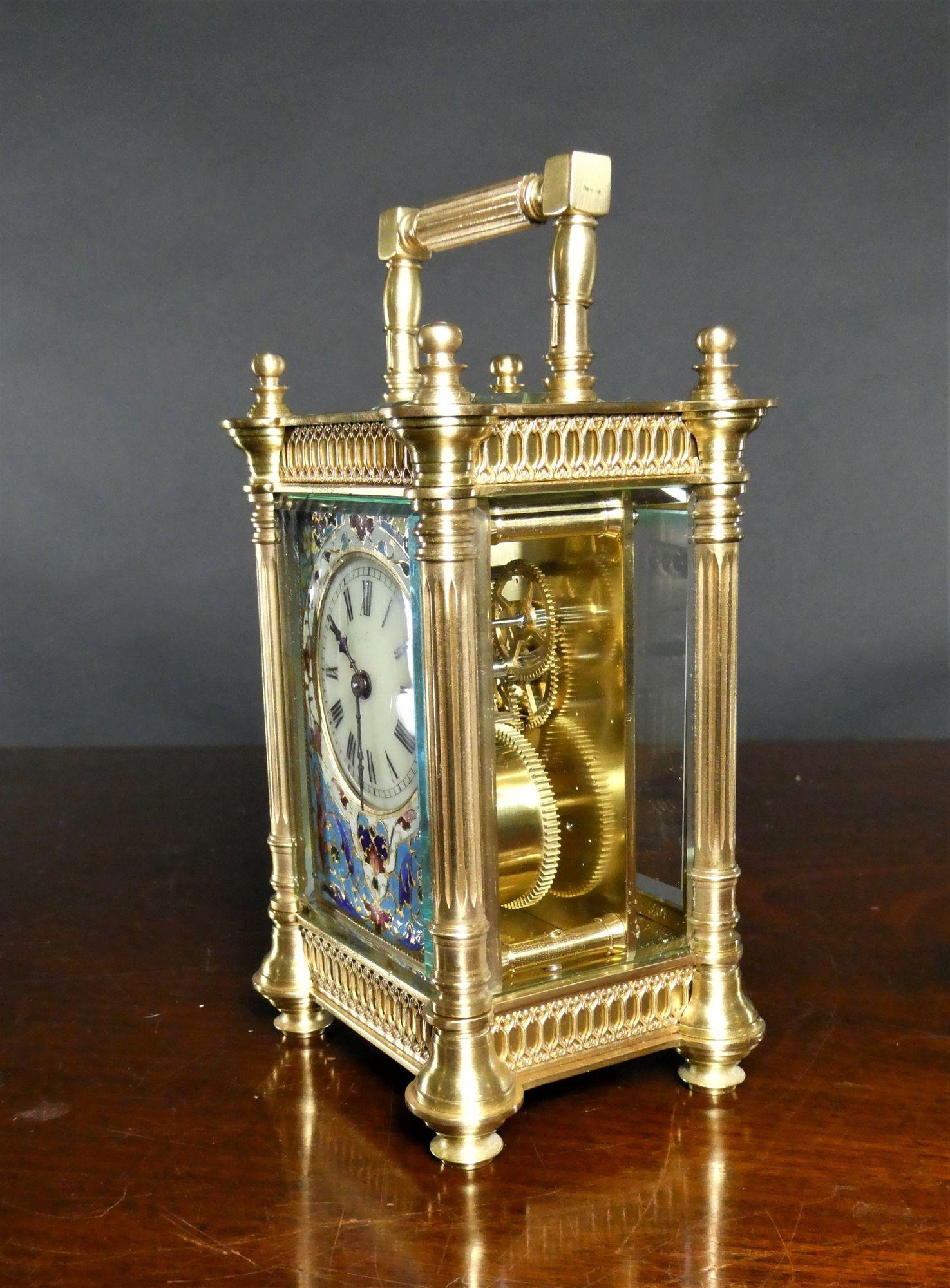 French brass cased carriage clock with bevelled glass, fluted pillars and decorative fretwork to all three sides and to the back of the case, surmounted by a fluted and reeded carrying handle.
Fine Champleve enamel decoration to the dial mask,
