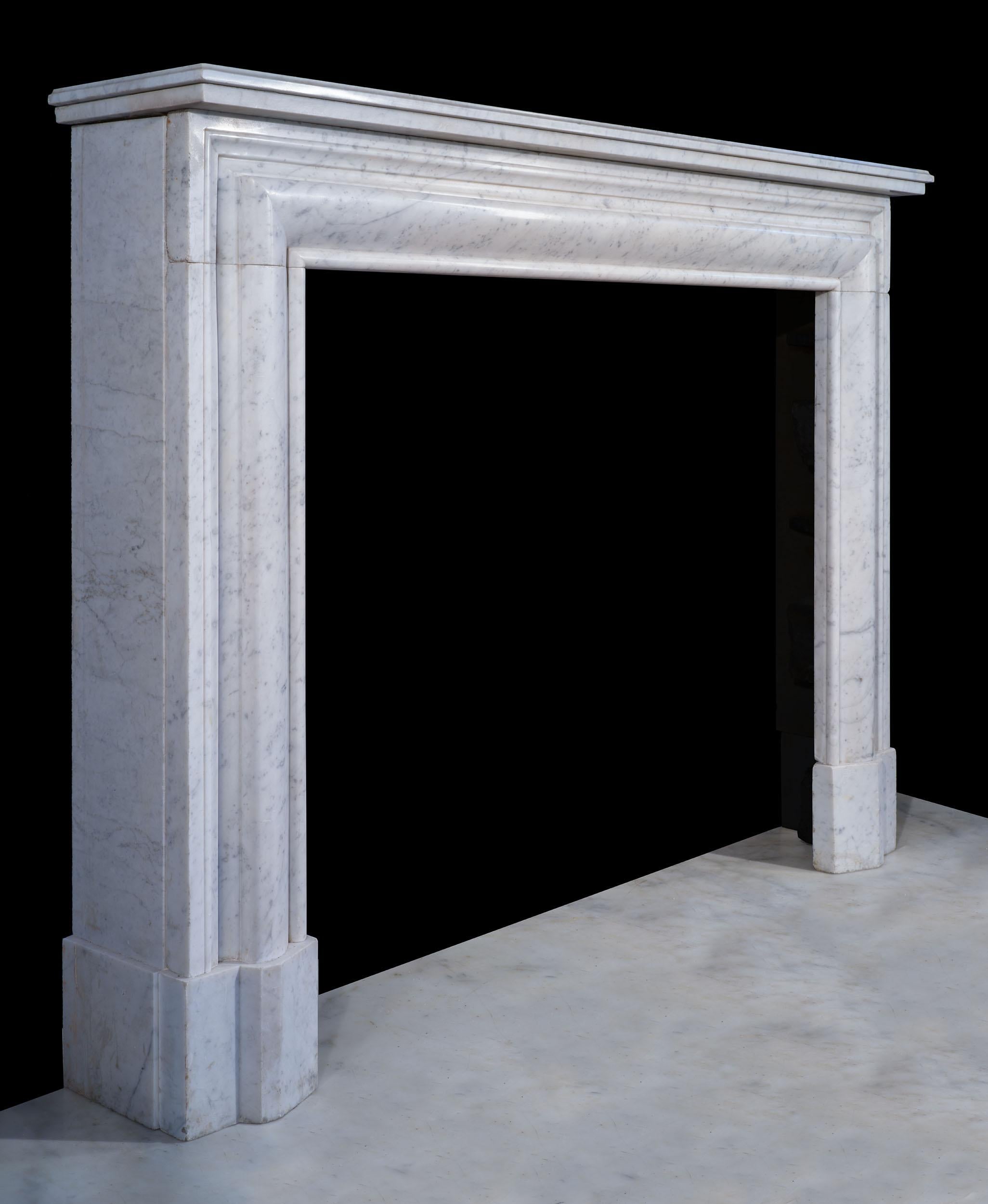 Un caminetto francese in marmo di carrara super semplice e molto elegante, in stile bolection. A differenza delle bolizioni inglesi, questo caminetto ha l'utile aggiunta di un ripiano che lo rende una scelta pratica quando vuoi decorare una