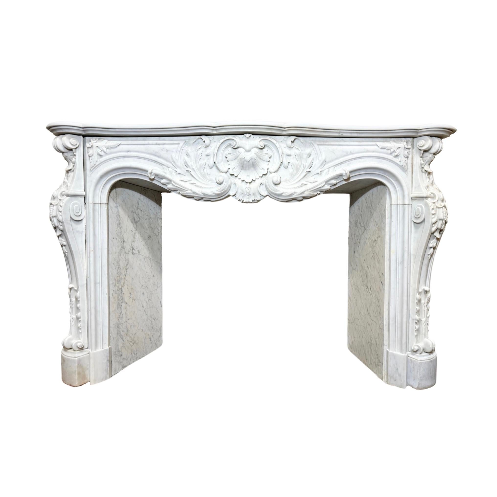 This elegant French Carrara Marble Mantel is crafted from high-quality white Carrara marble renowned for its durability and timeless beauty. Boasting an 1820s Louis the 15th style carved design, this stunning mantel is sure to elevate any living