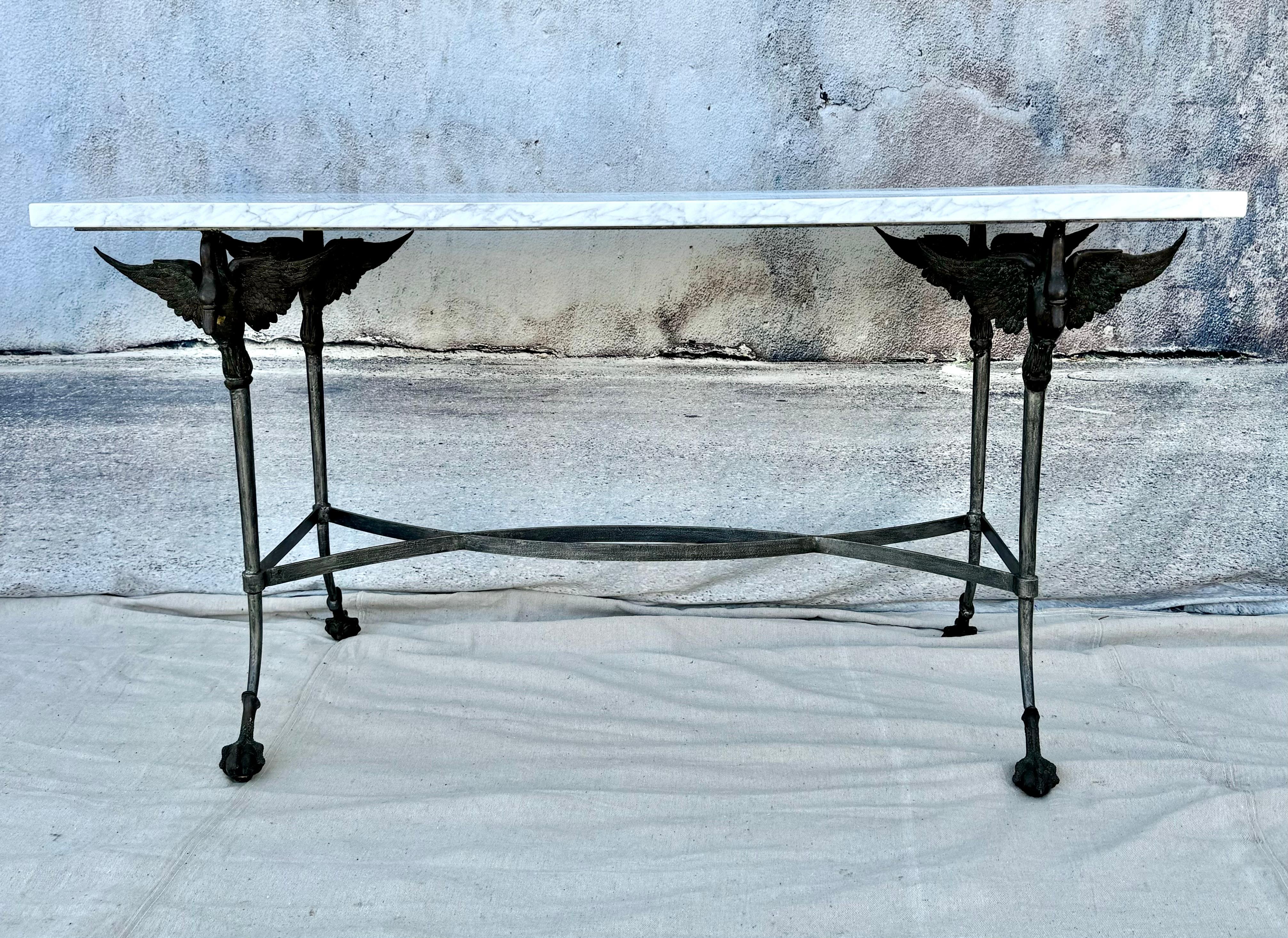 Stunning classically designed unique French polished steel base and marble top table from the 19th century. This table has unique designs with bronze swans on each corner, curved iron legs, culminating in iron swan talons wrapped around ball feet.