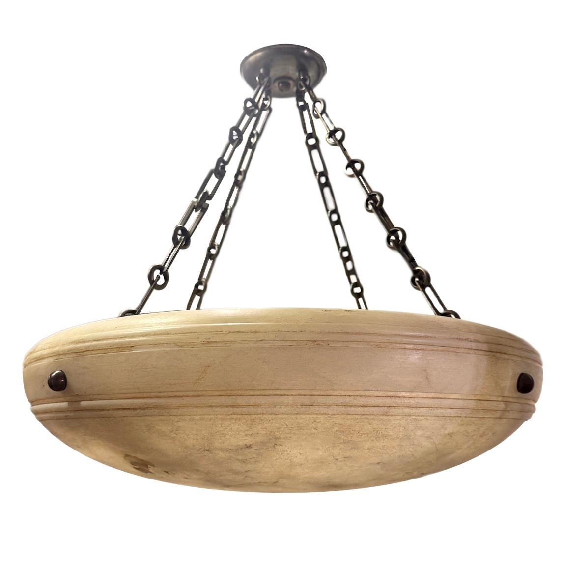 Un luminaire en albâtre sculpté français des années 1950 avec 3 lampes intérieures Edison, une chaîne et un baldaquin en bronze patiné.

Mesures :
Diamètre : 24.5