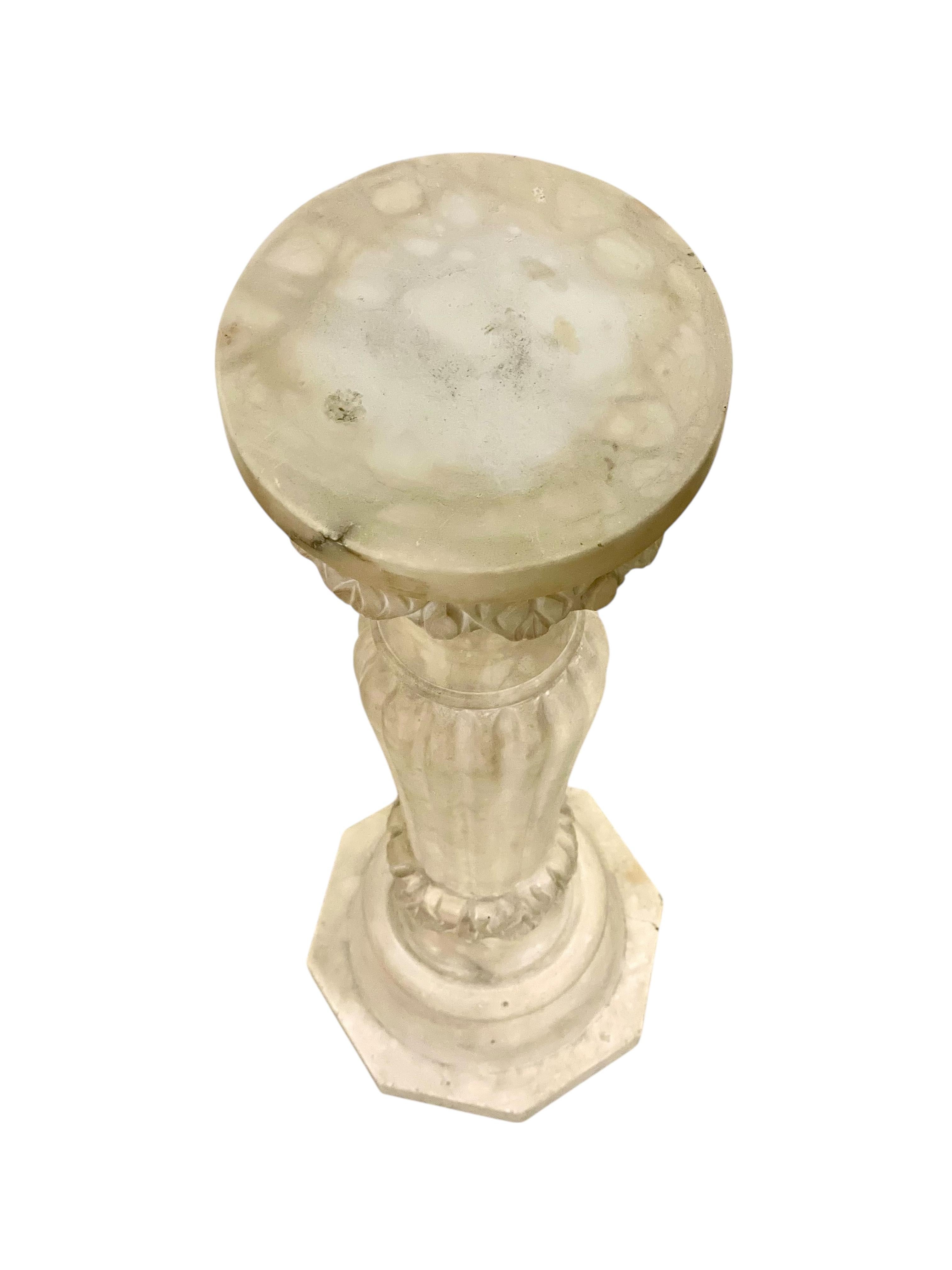 Cette élégante colonne française à piédestal en albâtre sculpté évoque magnifiquement l'esprit du design néoclassique, avec des lignes cannelées, un chapiteau à feuilles d'acanthe finement détaillé et une base octogonale audacieuse. Fabriquée en
