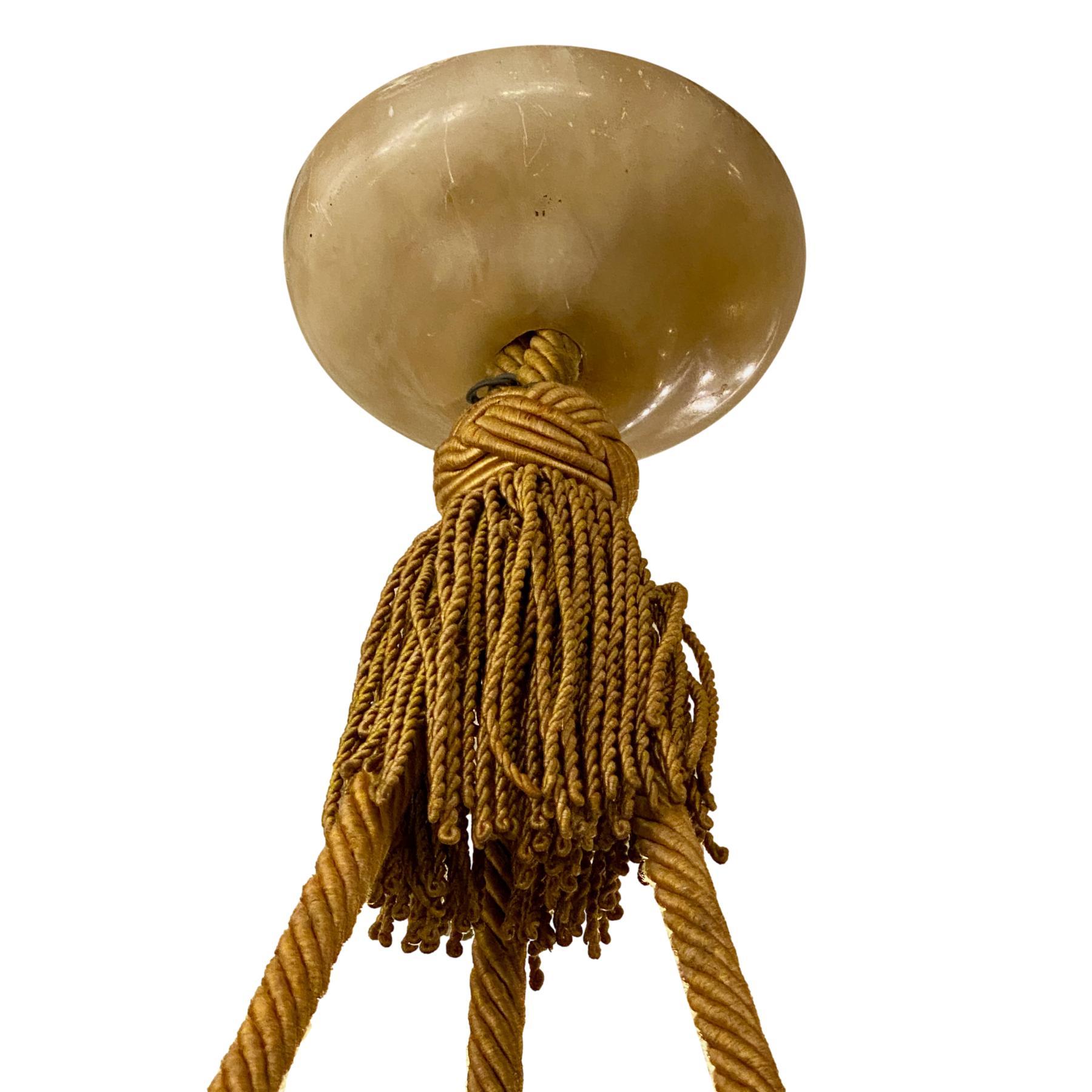 A circa 1940's French carved amber alabaster pendant light fixture with silk cords and tassel.

Measurements:
Current drop: 32