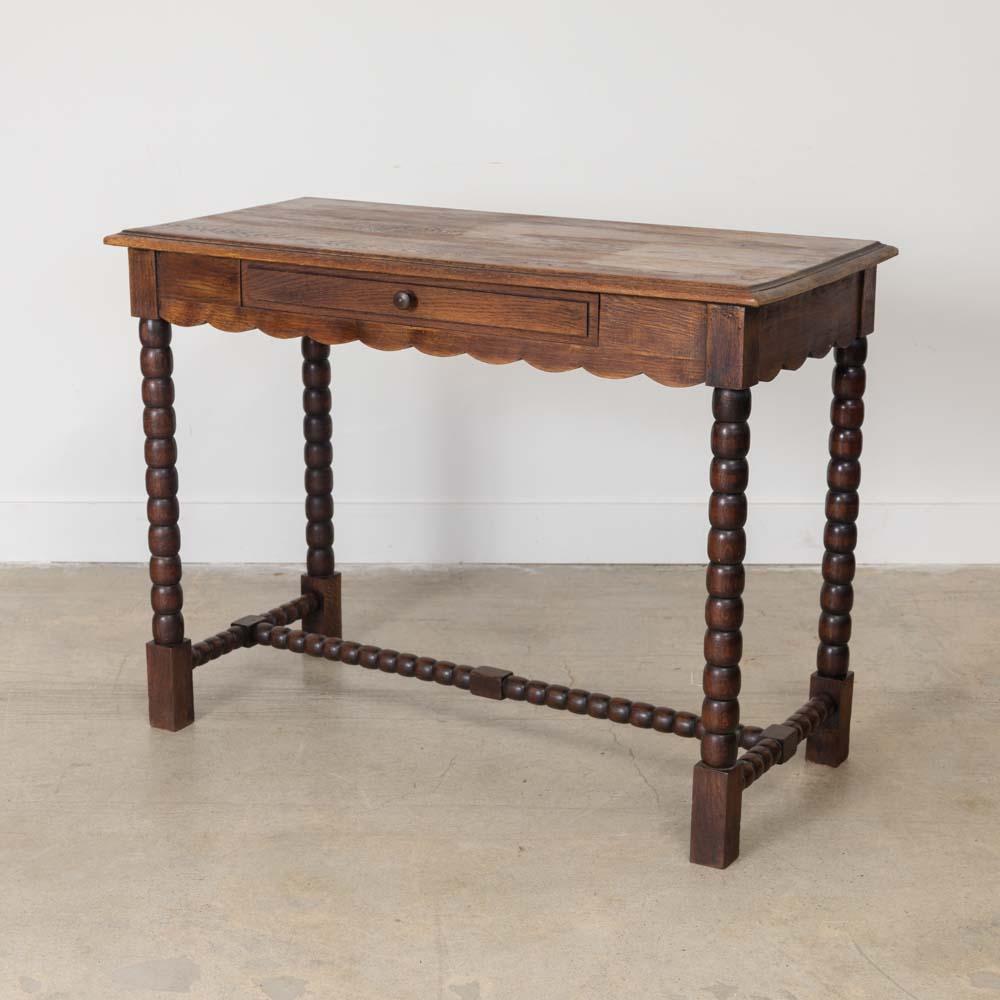 Lovely carved wood desk from France, 1940's. Rectangular top with four carved bobbin legs and beautiful scalloped wood apron on front. Single center drawer. Original finish shows nice age and patina. Perfect as a desk or console table.