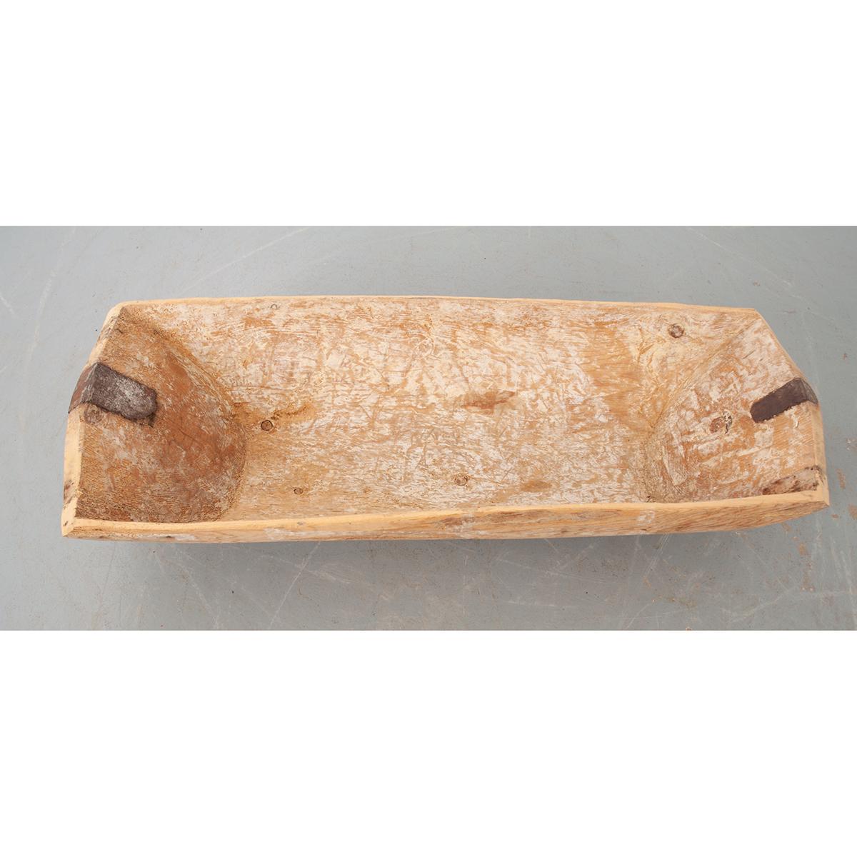 This is a French dough bowl, a wooden vessel used to mix bread dough. These bowls were found in every home and were typically carved from a large piece of wood. Now, it would make a nice conversation piece or decorate a dining room table. Circa