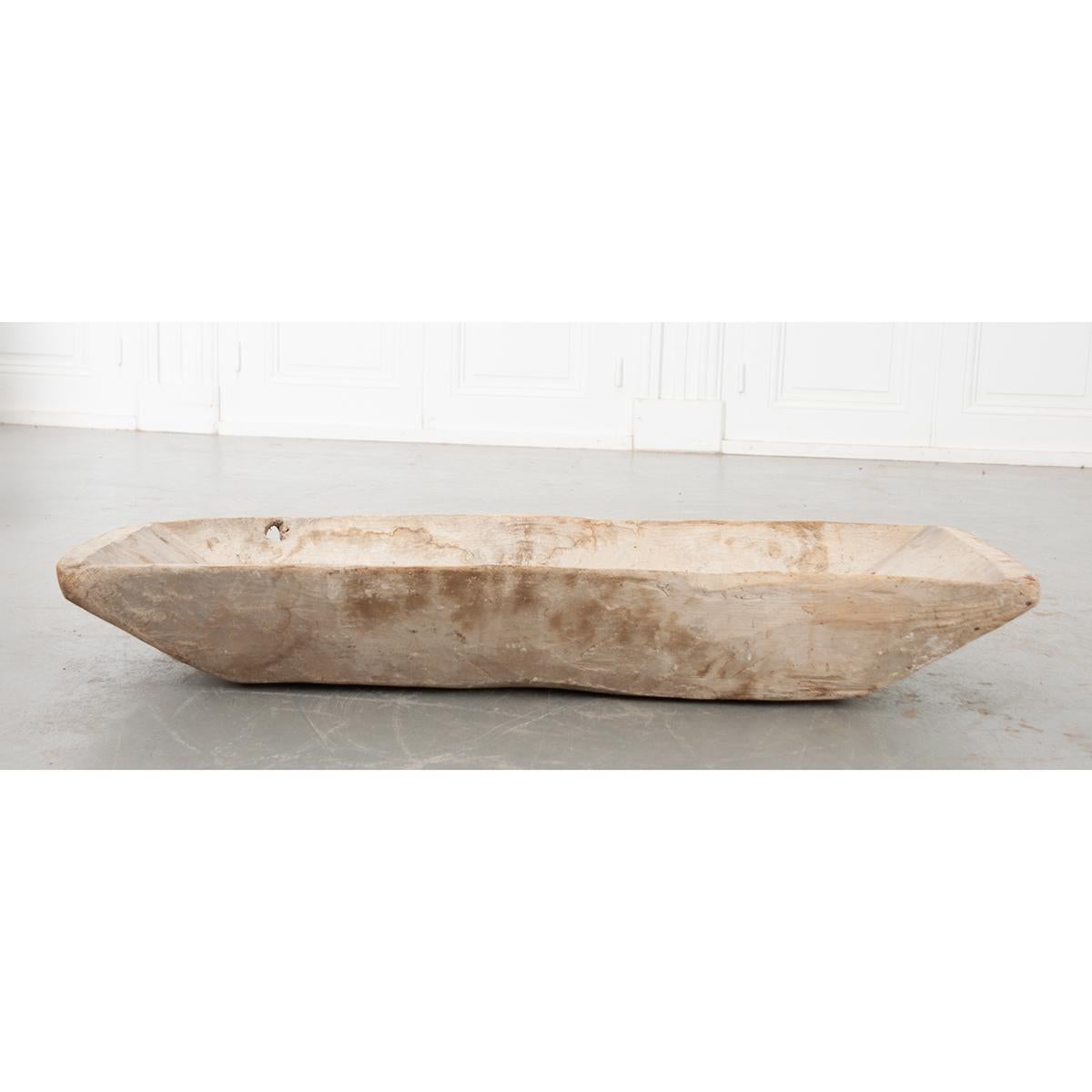 This is a French dough bowl, a wooden vessel used to mix bread dough. These bowls were found in every home and were typically carved from a large piece of wood. Now, it would make a nice conversation piece or decorate a dining room table. Circa 1880.