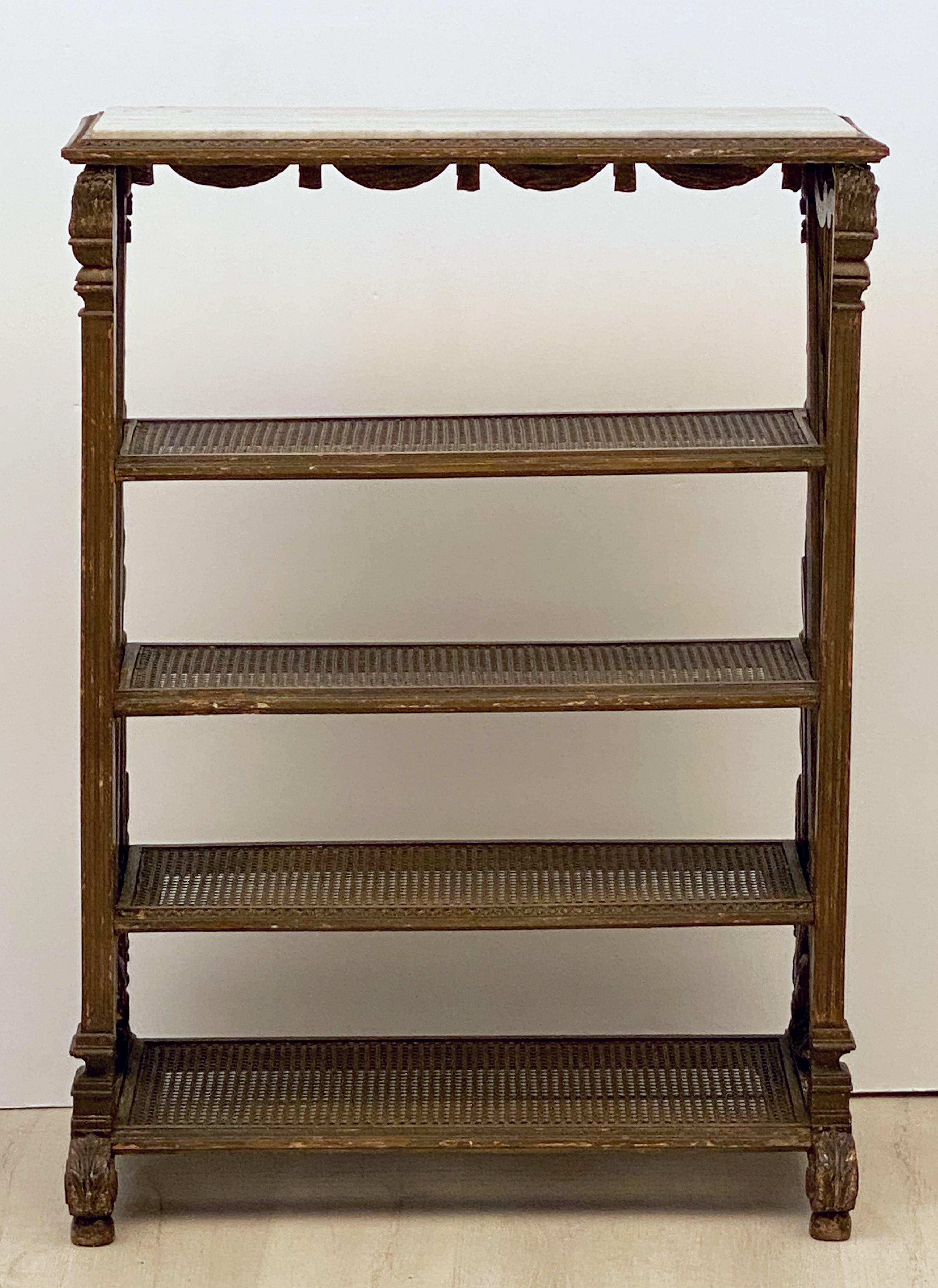 A fine French étagère or shelving unit from the 19th century, featuring a marble inset to the top over four shelves.
Each shelf with perfectly intact cane, the sides in the form of stylized harps, flanked with carved wood bulrushes.
The whole