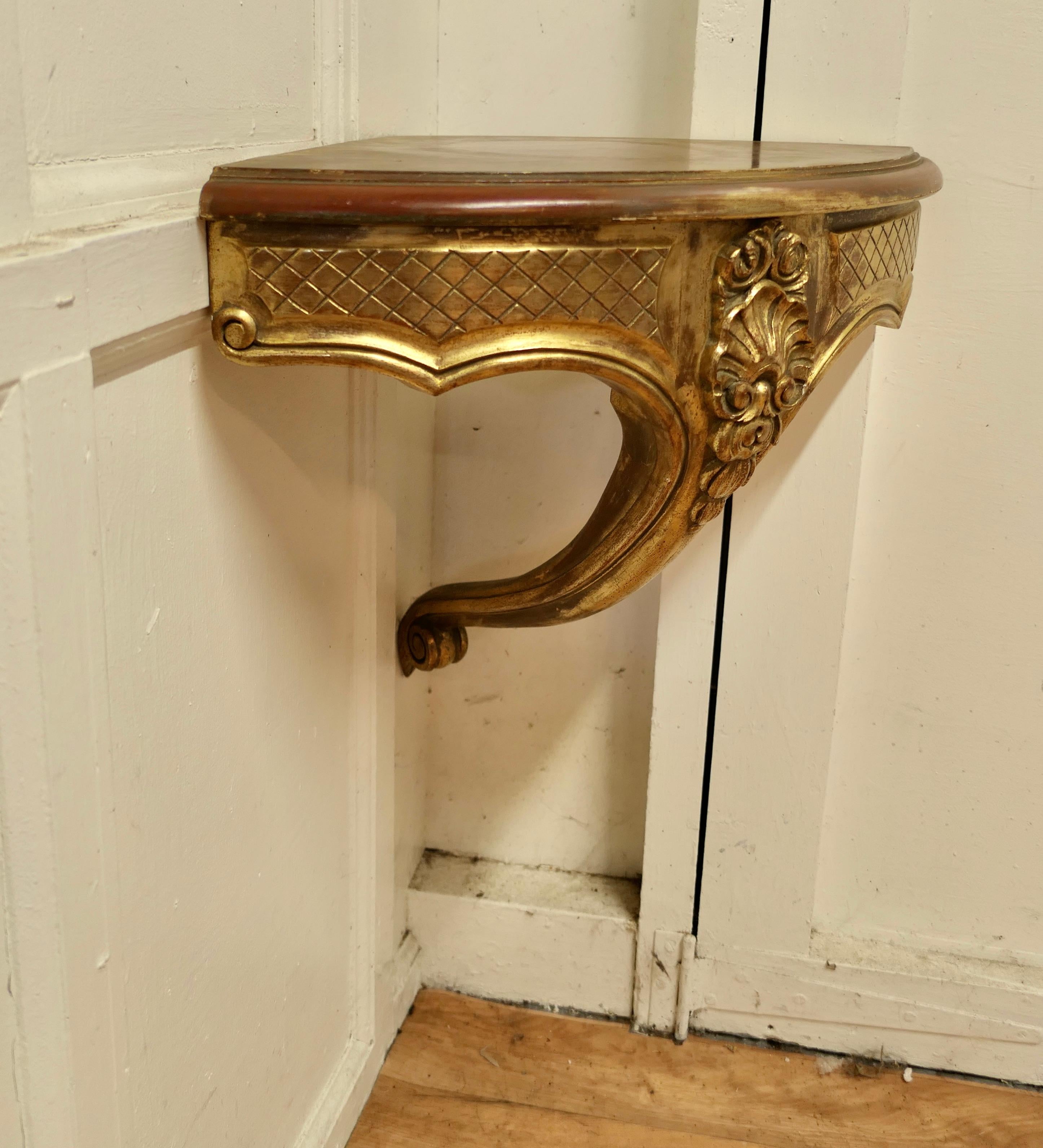 French Carved Gilt Corner Console wall shelf

A beautifully carved gilt console shelf, it has a bow shaped front and a carved leg
This is a good-looking piece and the Gold has a good bright colour, worn a bit with some of the red oxide