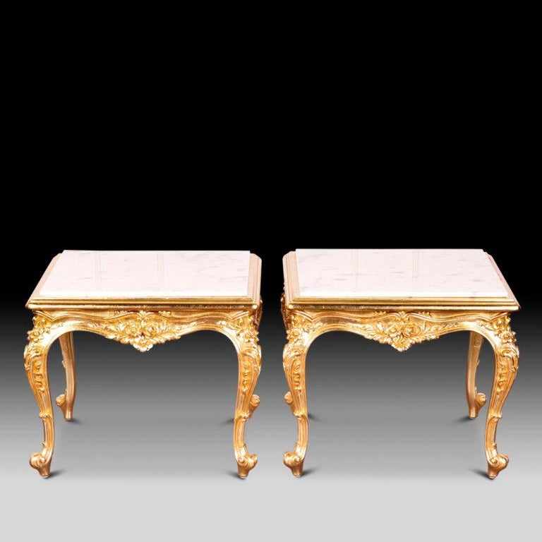 An unusual and elegant pair of vintage French marble top side tables with ornately carved and gilt Louis XV style frames featuring scrolls, flowers, leaves etc. Large original matching square coffee table also available- see photos.