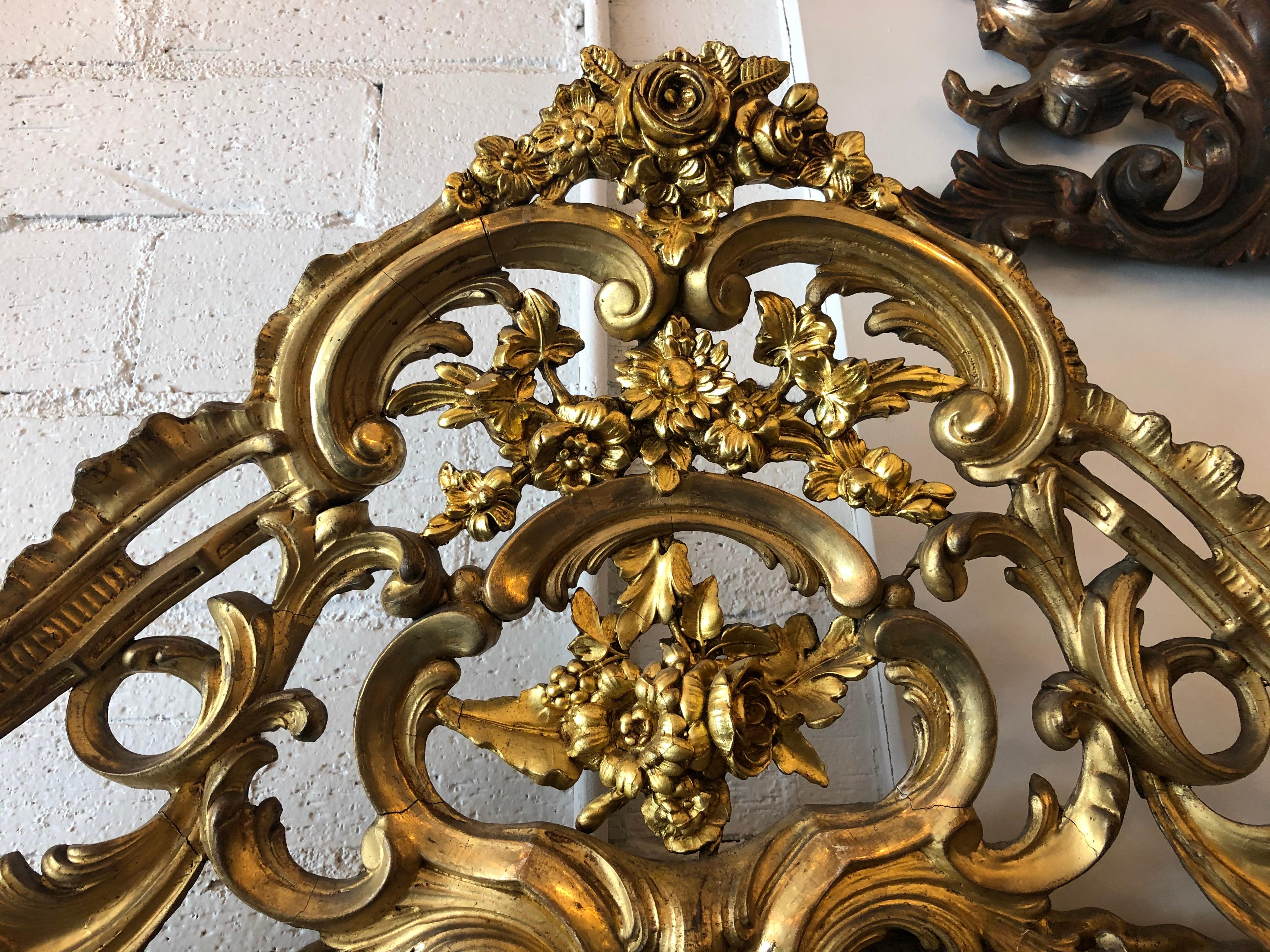 Französischer geschnitzter und vergoldeter Spiegel aus der Zeit Napoleons III., 19. Jh. Die flache Spiegelplatte wird von einem kunstvoll geschnitzten, blattförmigen Rahmen eingefasst, der von geschnitzten floralen Akzenten flankiert wird.