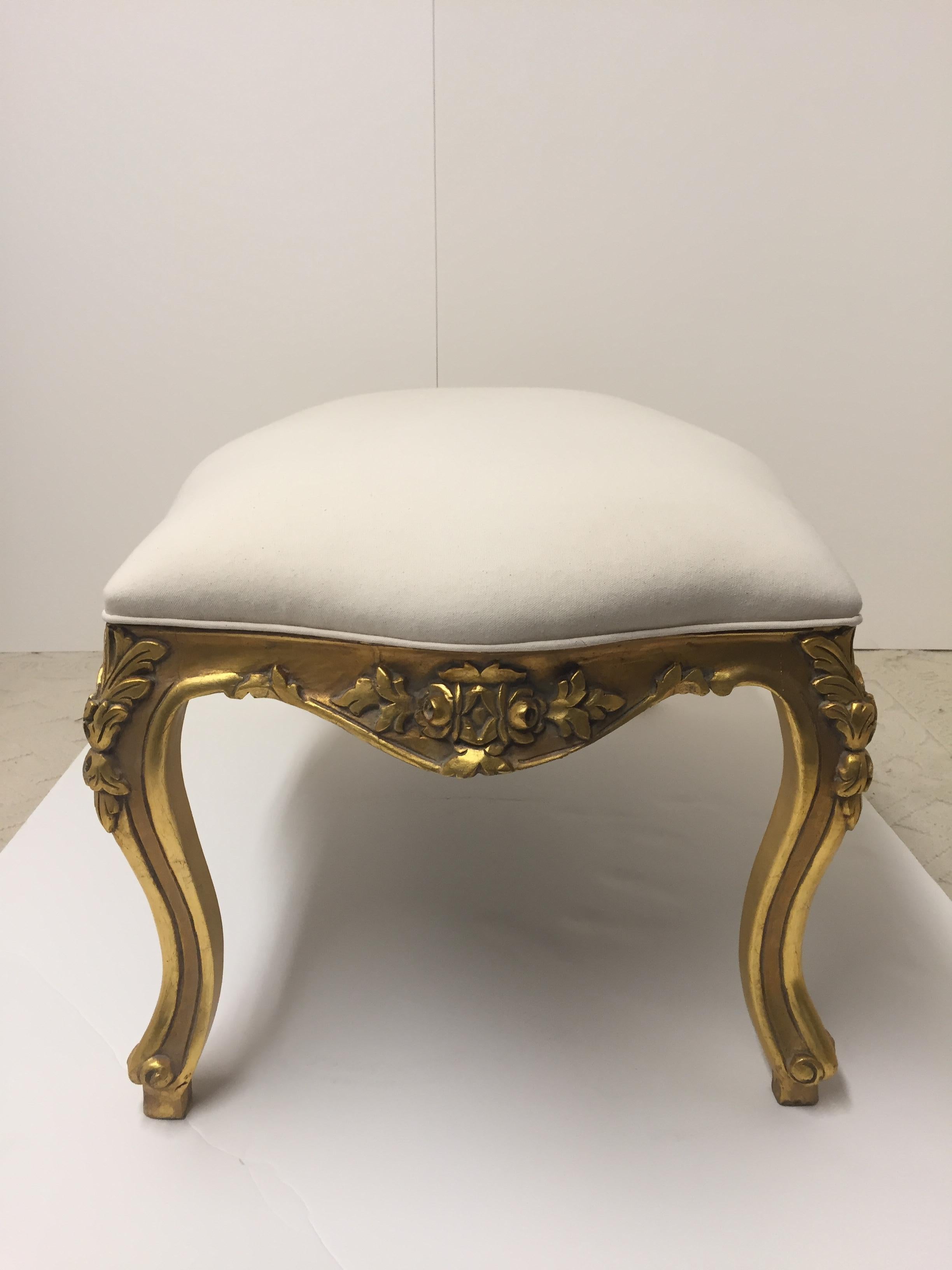 Glamorous giltwood bench with pretty cabriole legs and carving, newly upholstered in elegant white cotton duck.
 
