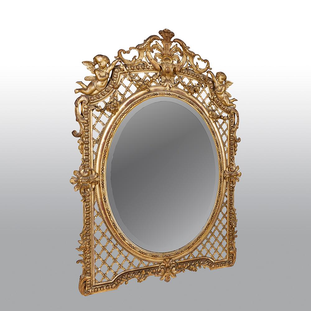 A fine French mirror from the second half of the 19th century, features a richly carved giltwood frame with cherubs upon a raised lattice designed frame.