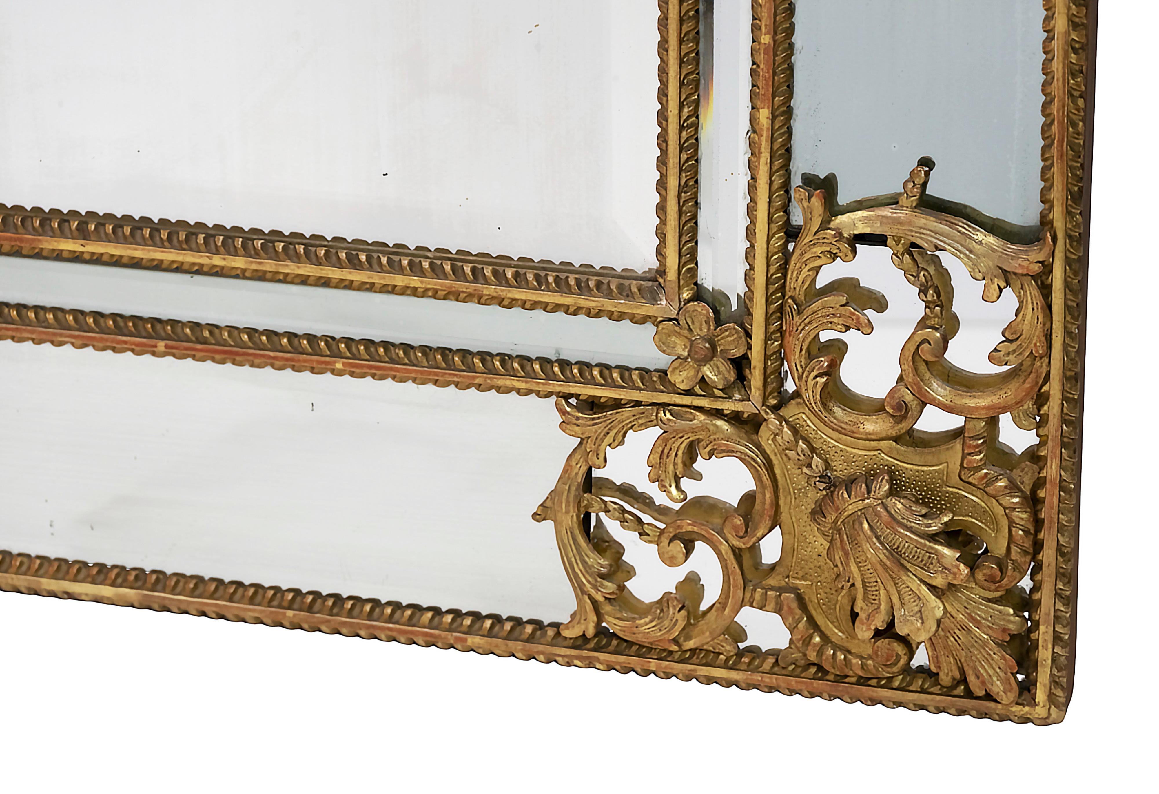 Miroir mural en bois sculpté et doré, d'époque Régence, XVIIIe siècle.
Le cadre est décoré de motifs feuillagés détaillés dans les coins et d'une belle couronne supérieure richement sculptée d'éléments floraux avec une grande palmette centrale.
